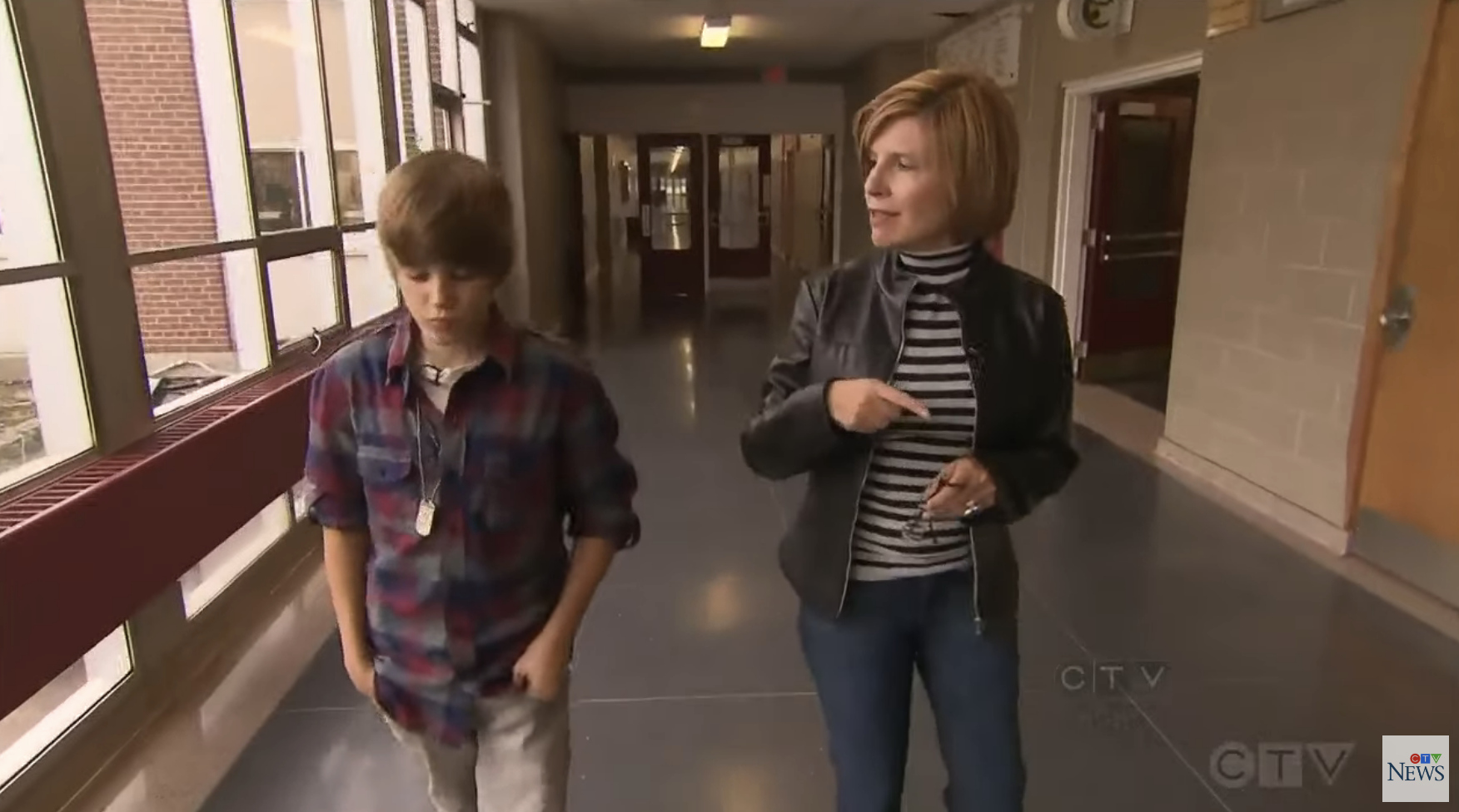 Close-up of Justin walking down a hallway with an interviewer