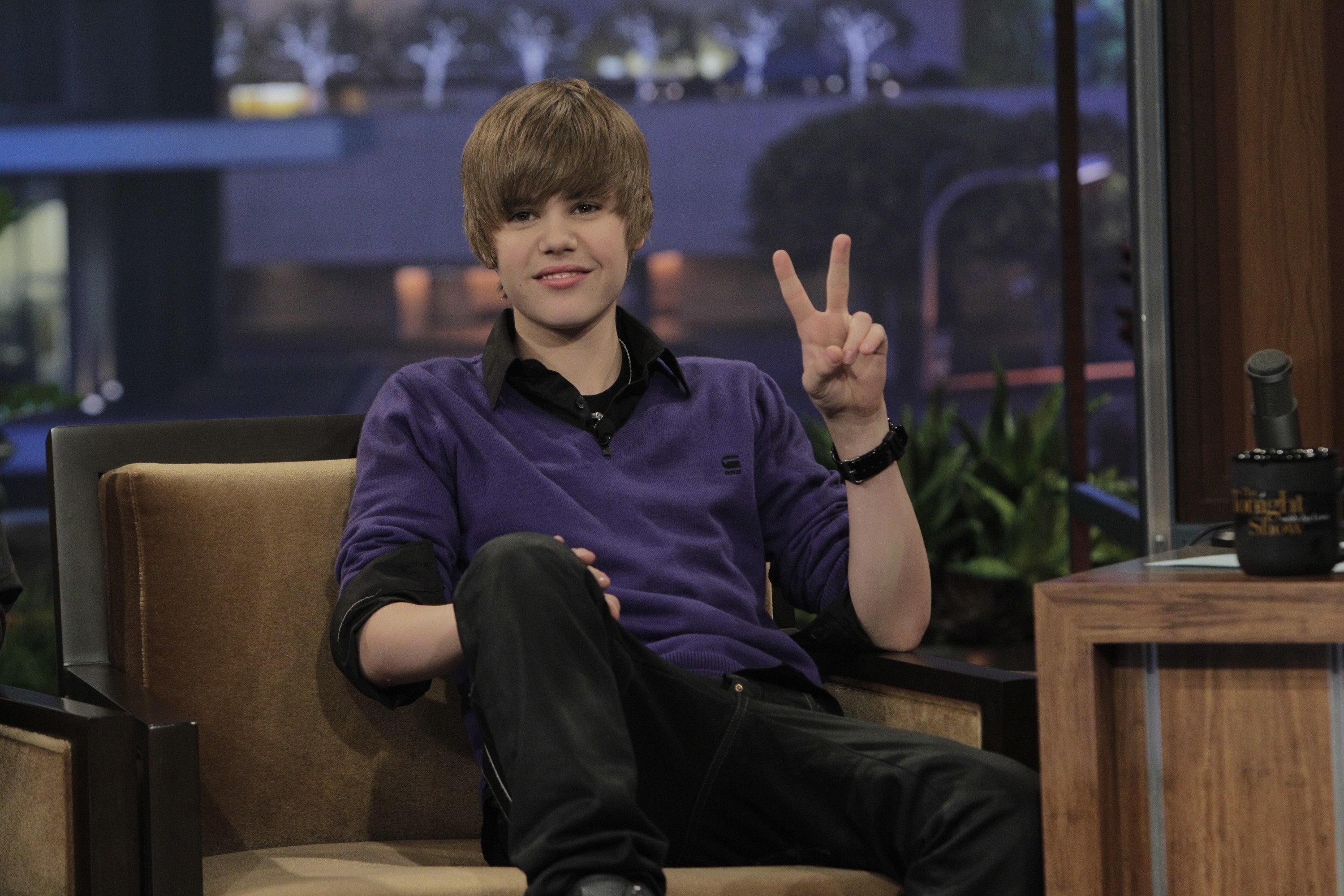Close-up of Justin as a teen giving the peace sign on a talk show