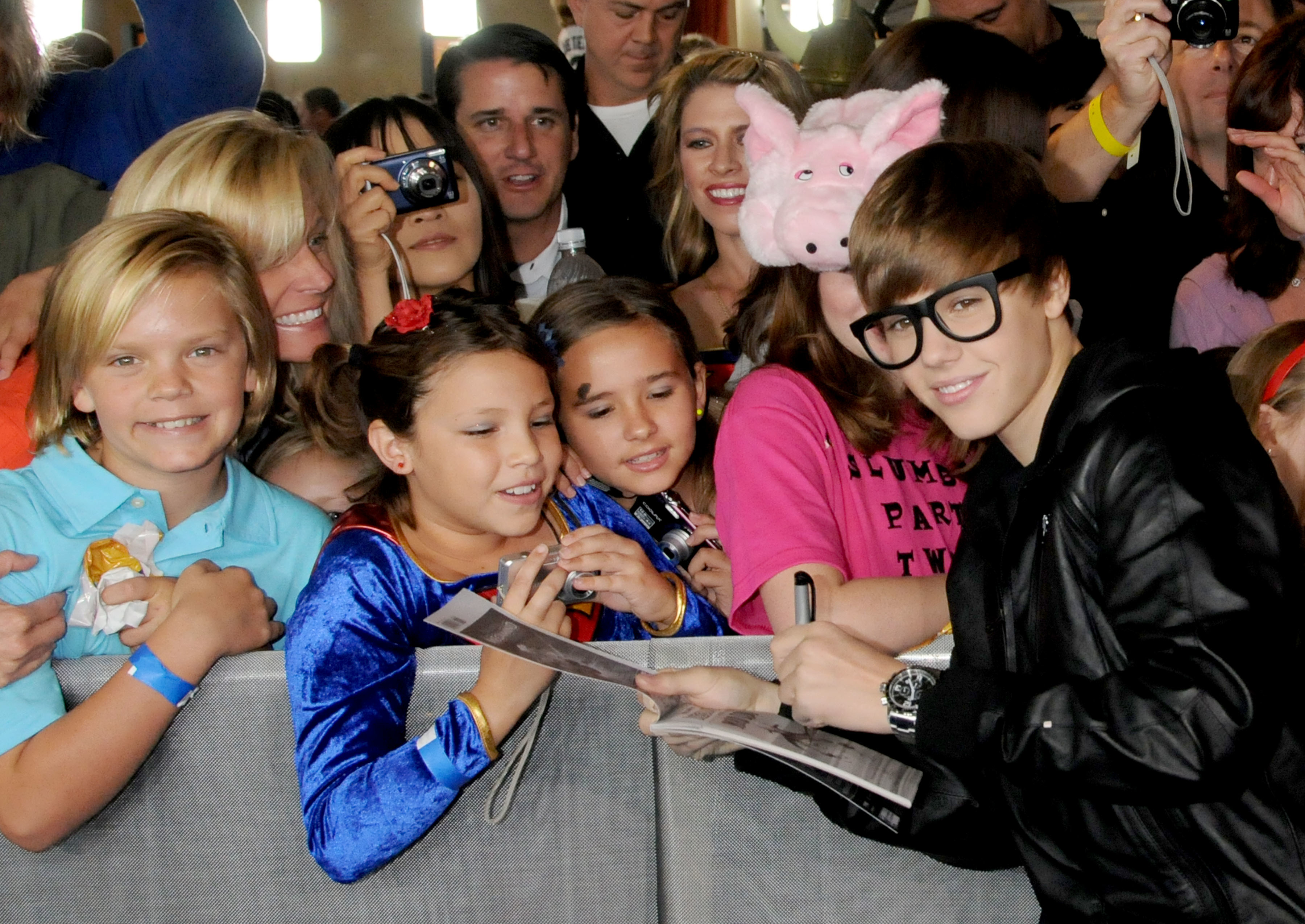 Close-up of Justin as a teen signing autographs for fans