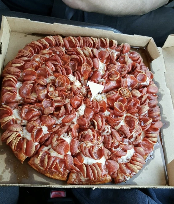 A pizza completely covered in pepperoni