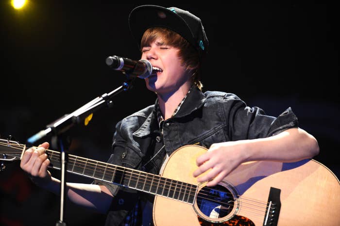 Close-up of Justin as a teen singing and playing guitar