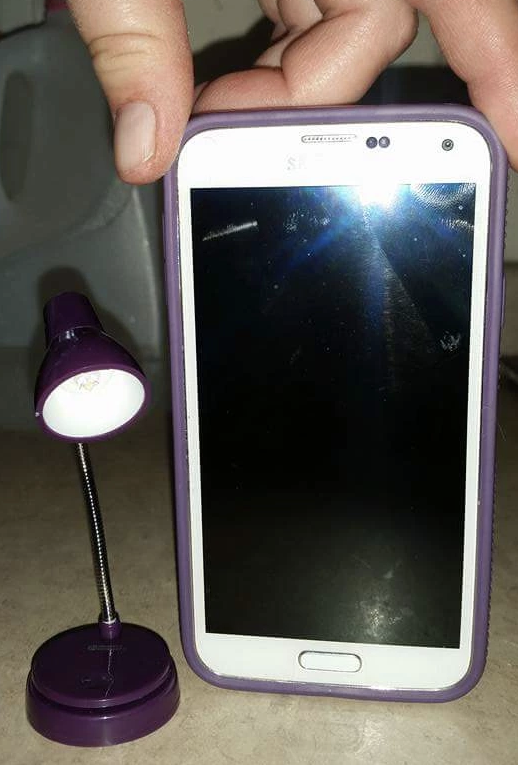 a tiny lamp next to a smartphone