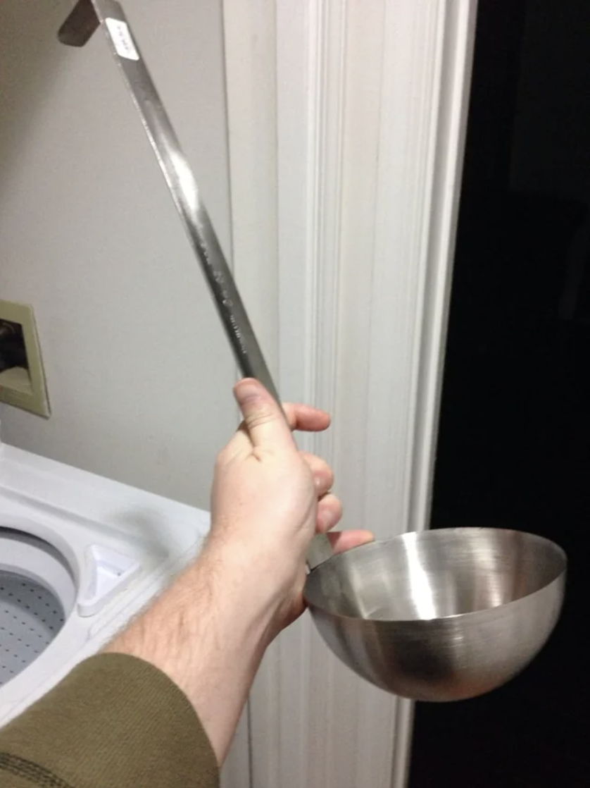 A person holding a giant ladle