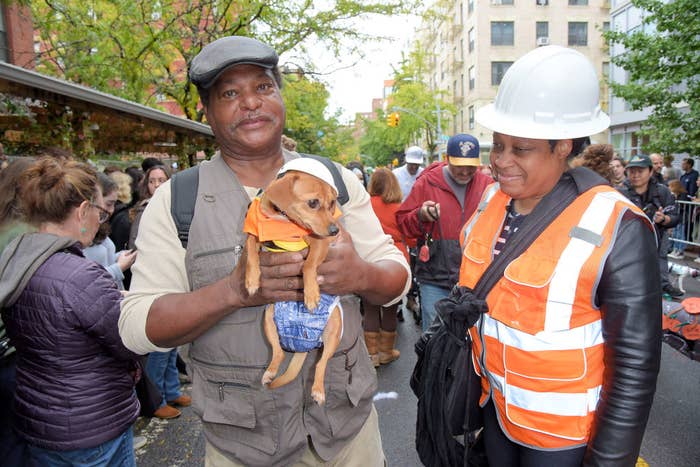 image of a man and his wife holding their dog dressed as a construction worker