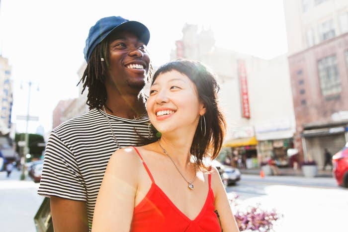 A couple smiling in a big city