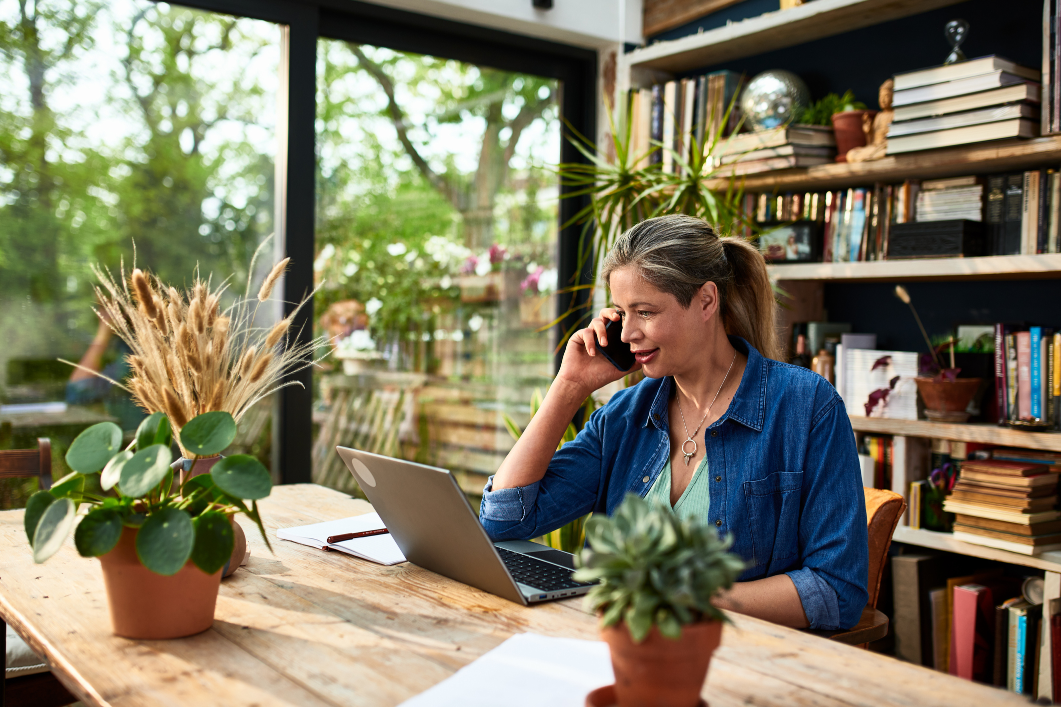 A woman on the phone in front of her laptop