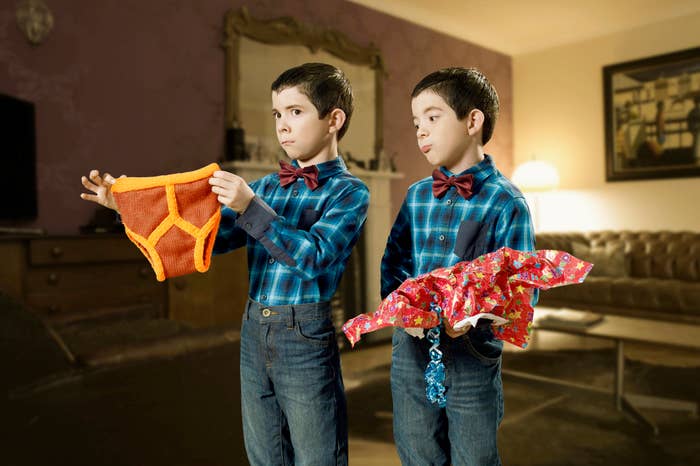 Twin boys in bow ties holding clothes