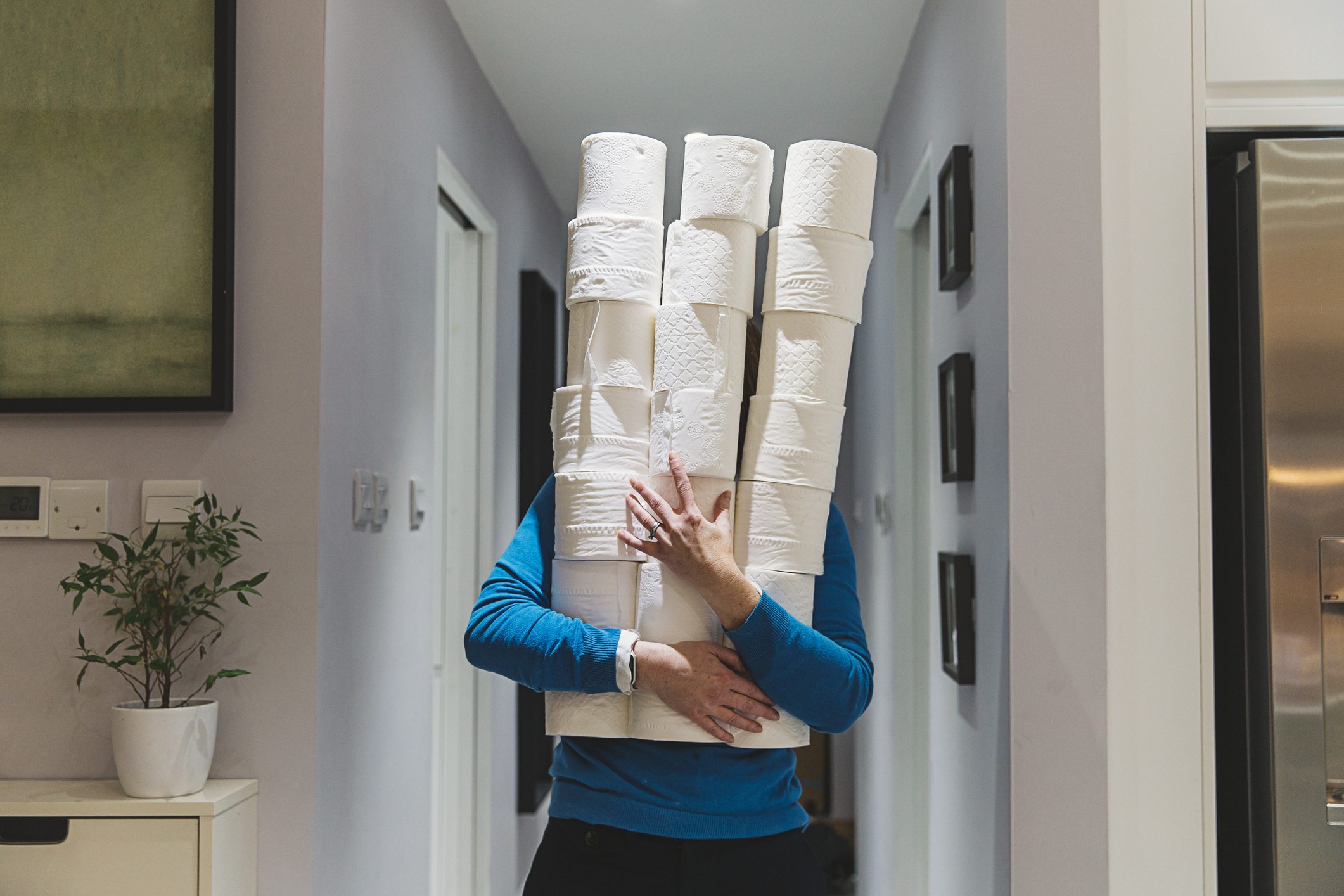 A person is holding a tower of toilet paper