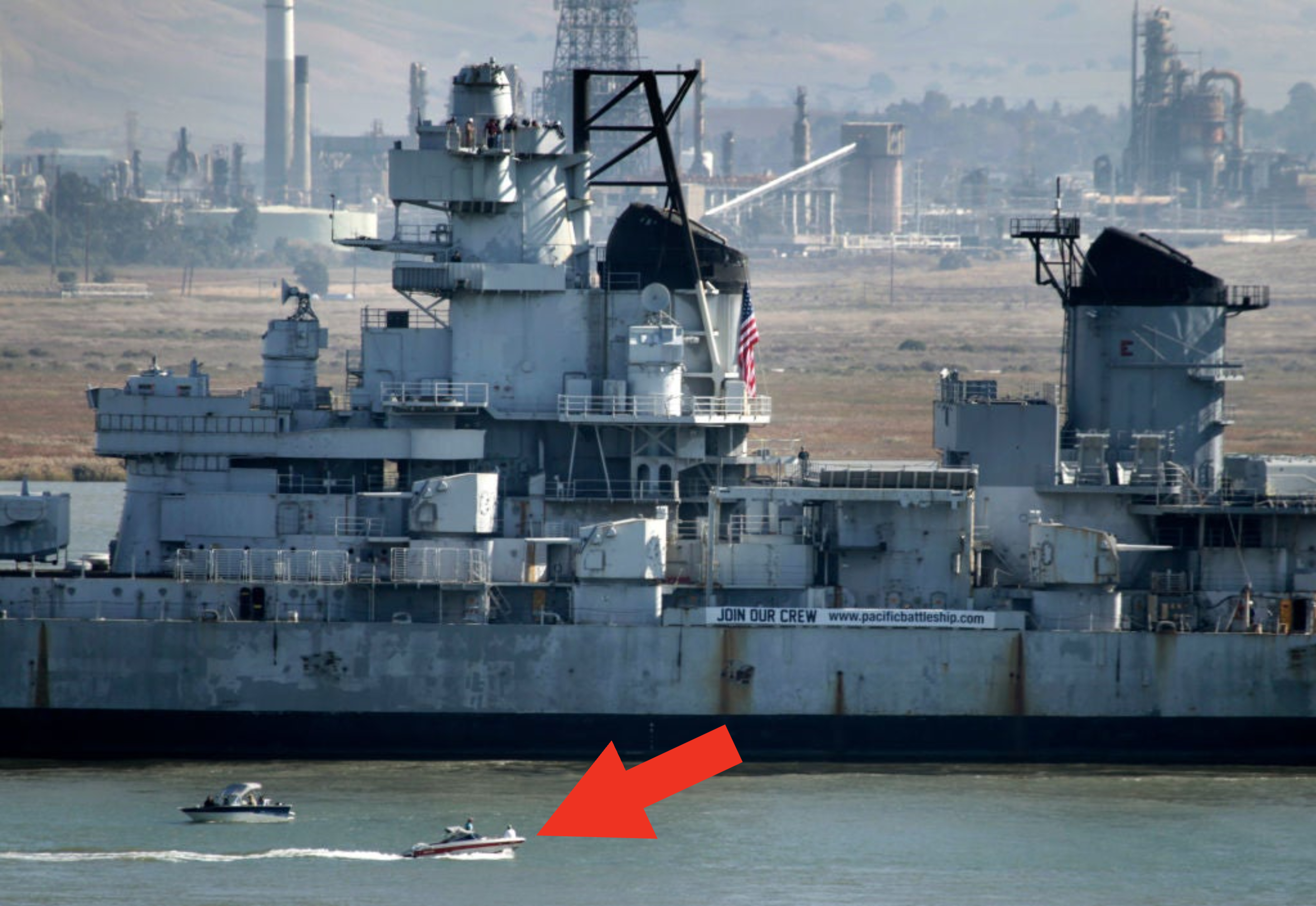 A small boat next to a battleship