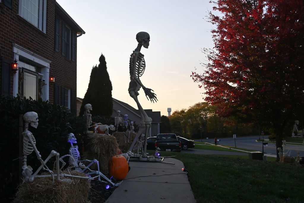 giant skeleton towering over smaller ones in someone&#x27;s yard