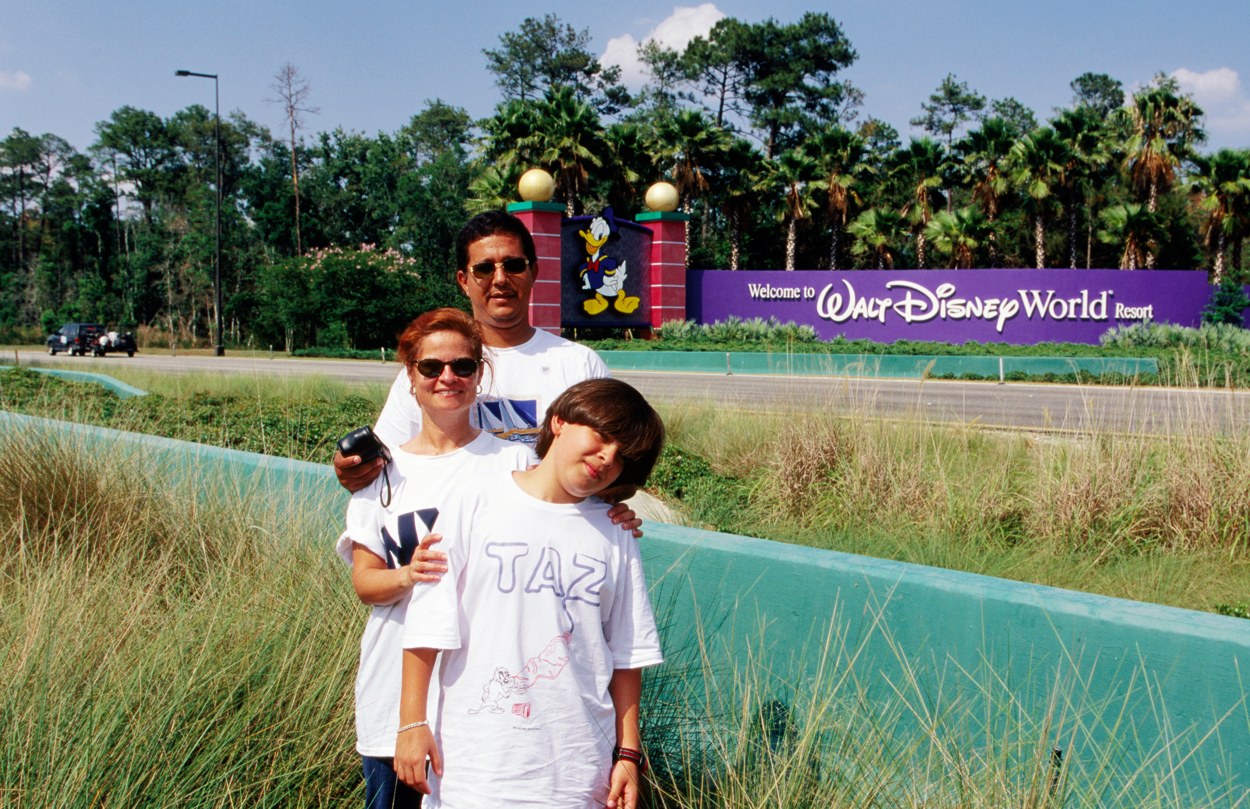A family standing in front of the Walt Disney World sign