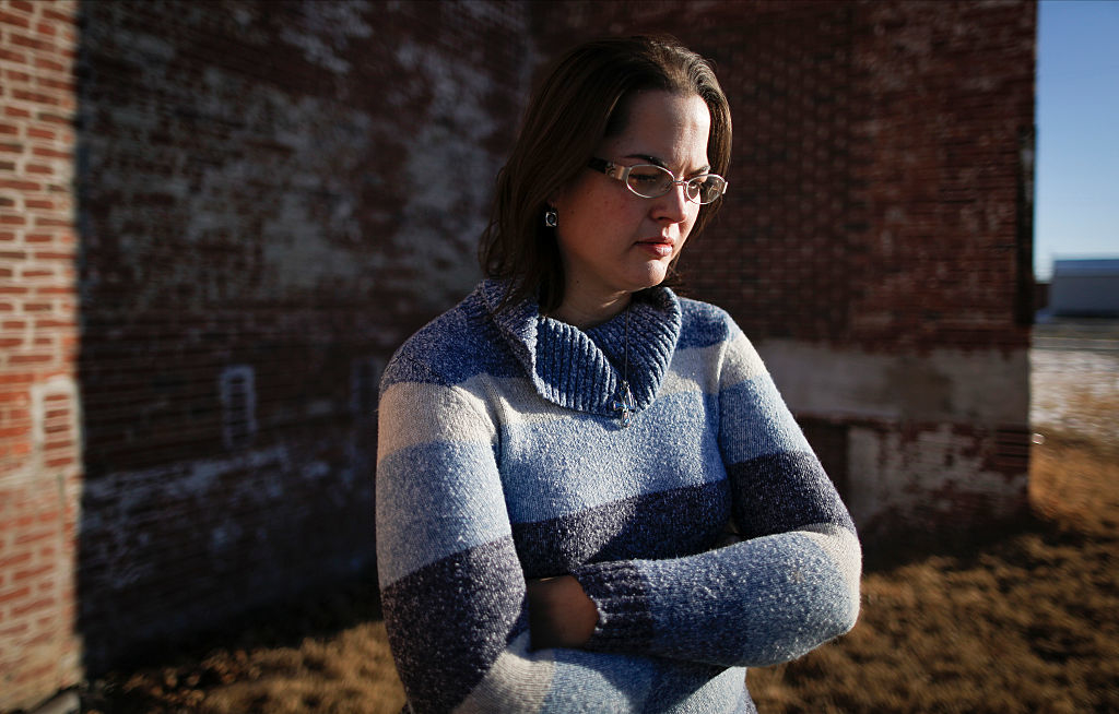 Rawson wearing a sweater outside a building with her arms folded