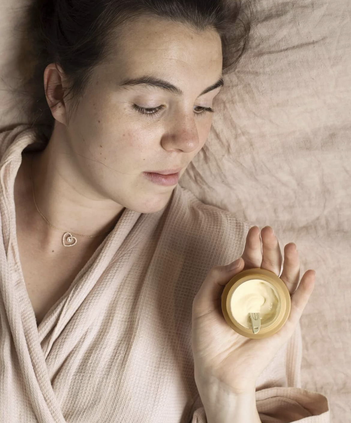 a person laying down while holding the night cream