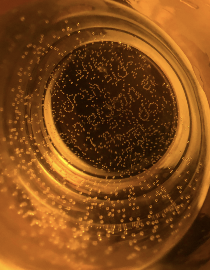 Bubbles making letters and patterns on the bottom of a bottle