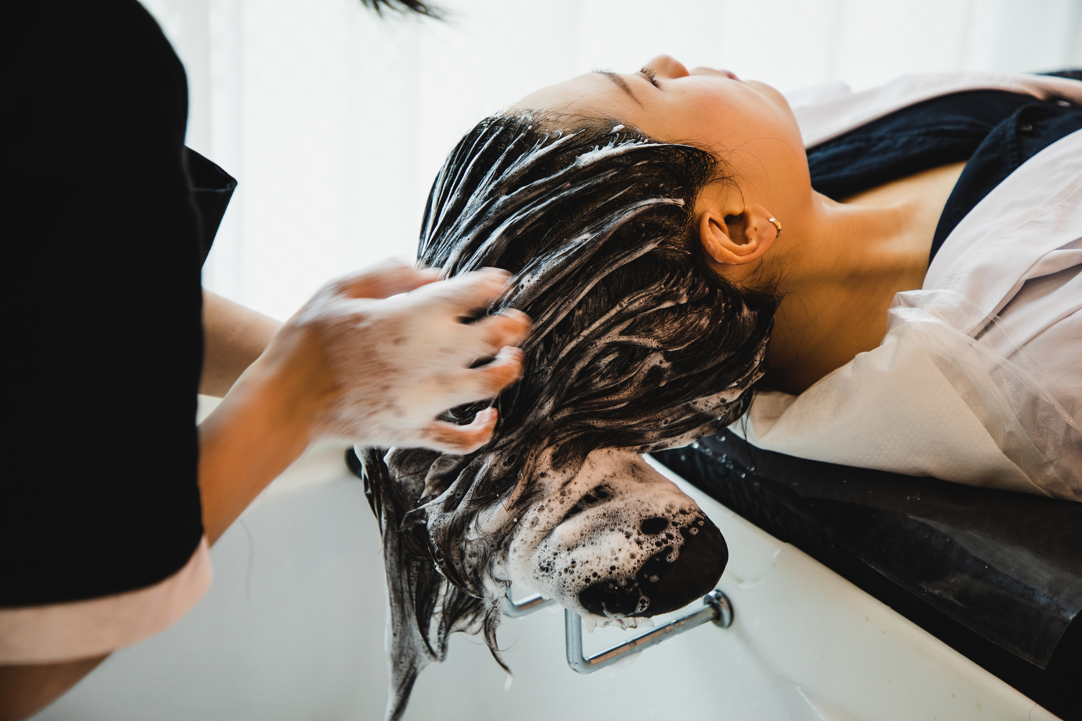 A woman is getting her hair washed