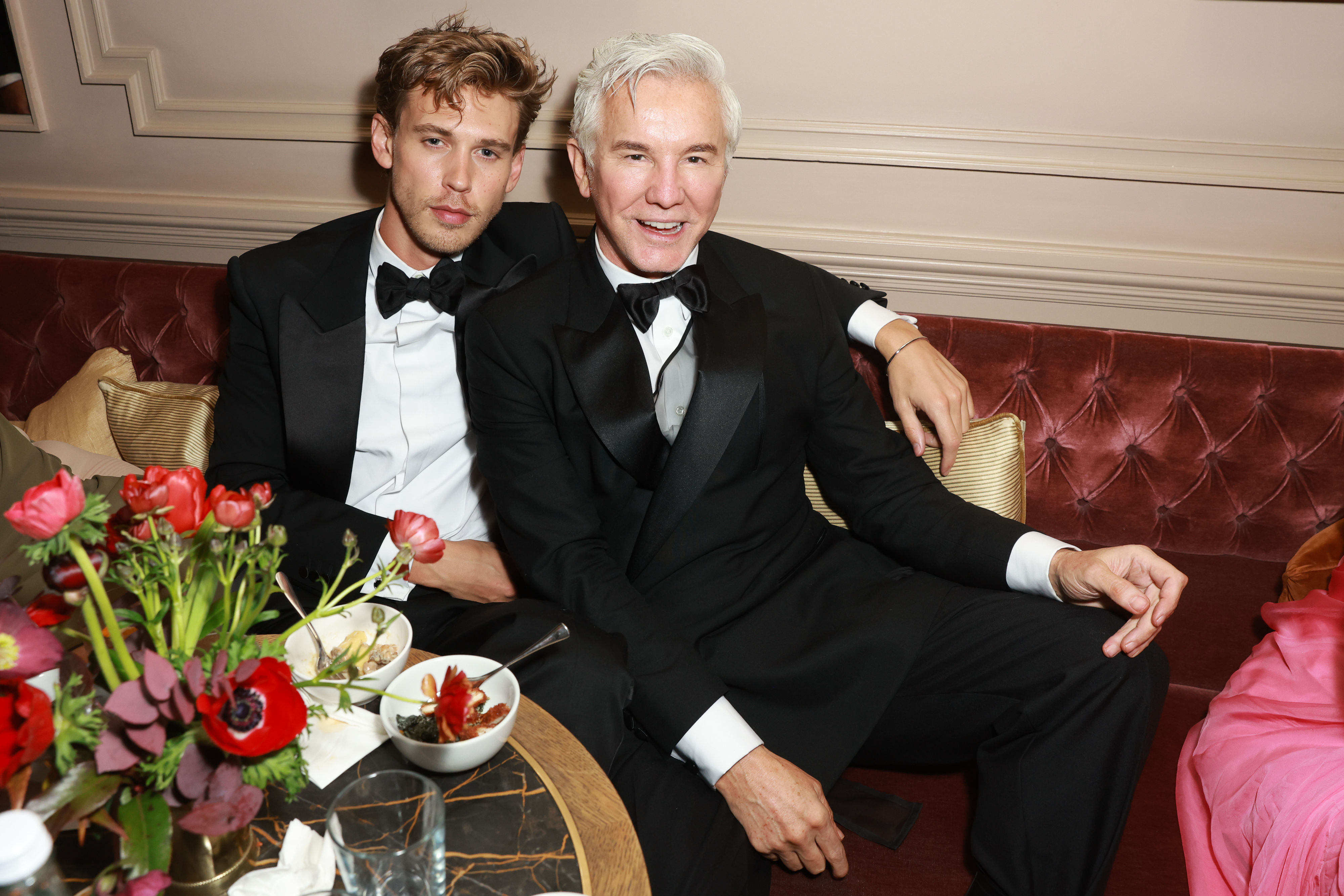 Austin Butler with Baz Luhrmann sitting on a couch at an event