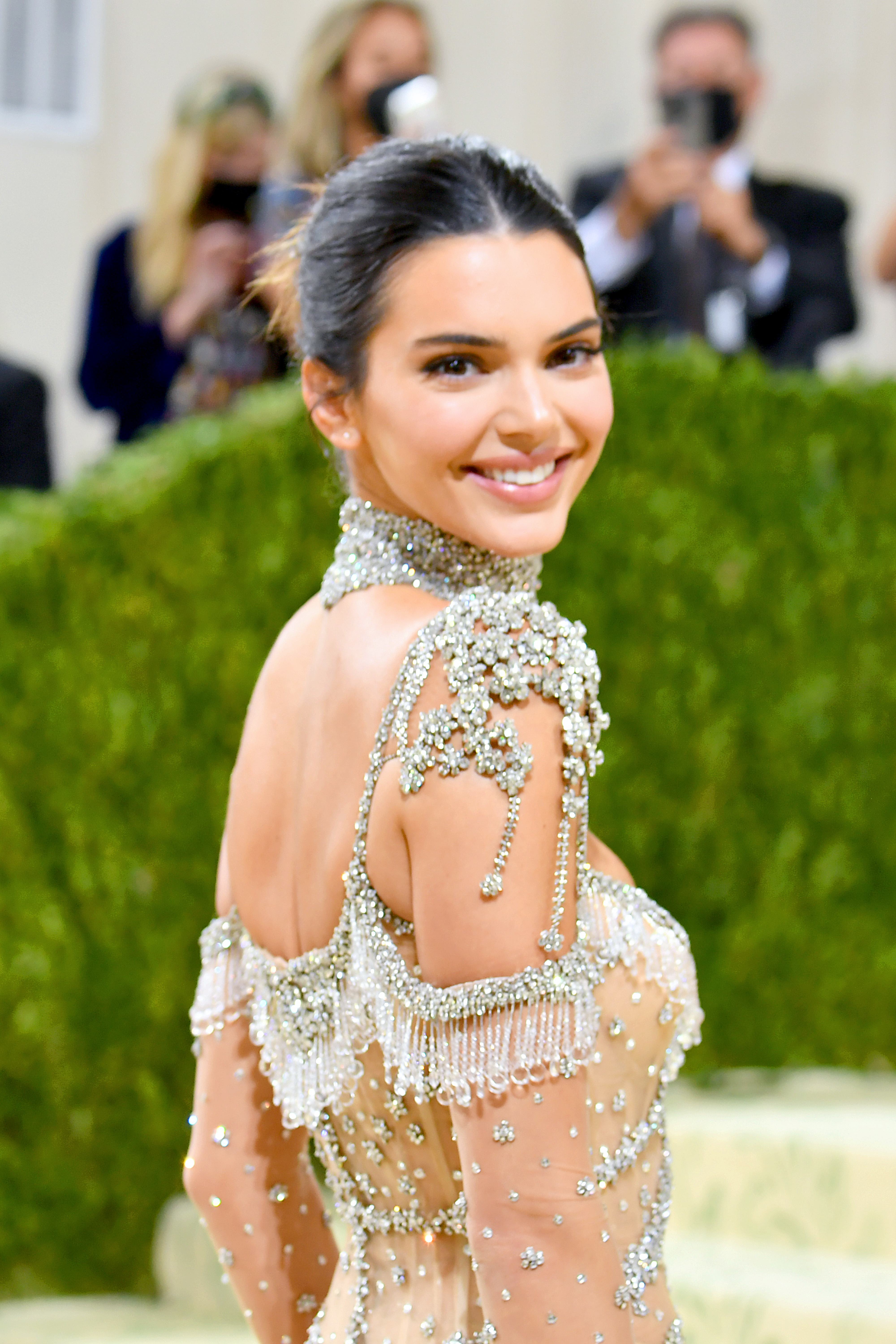 Closeup of Kendall Jenner smiling as she looks over her shoulder