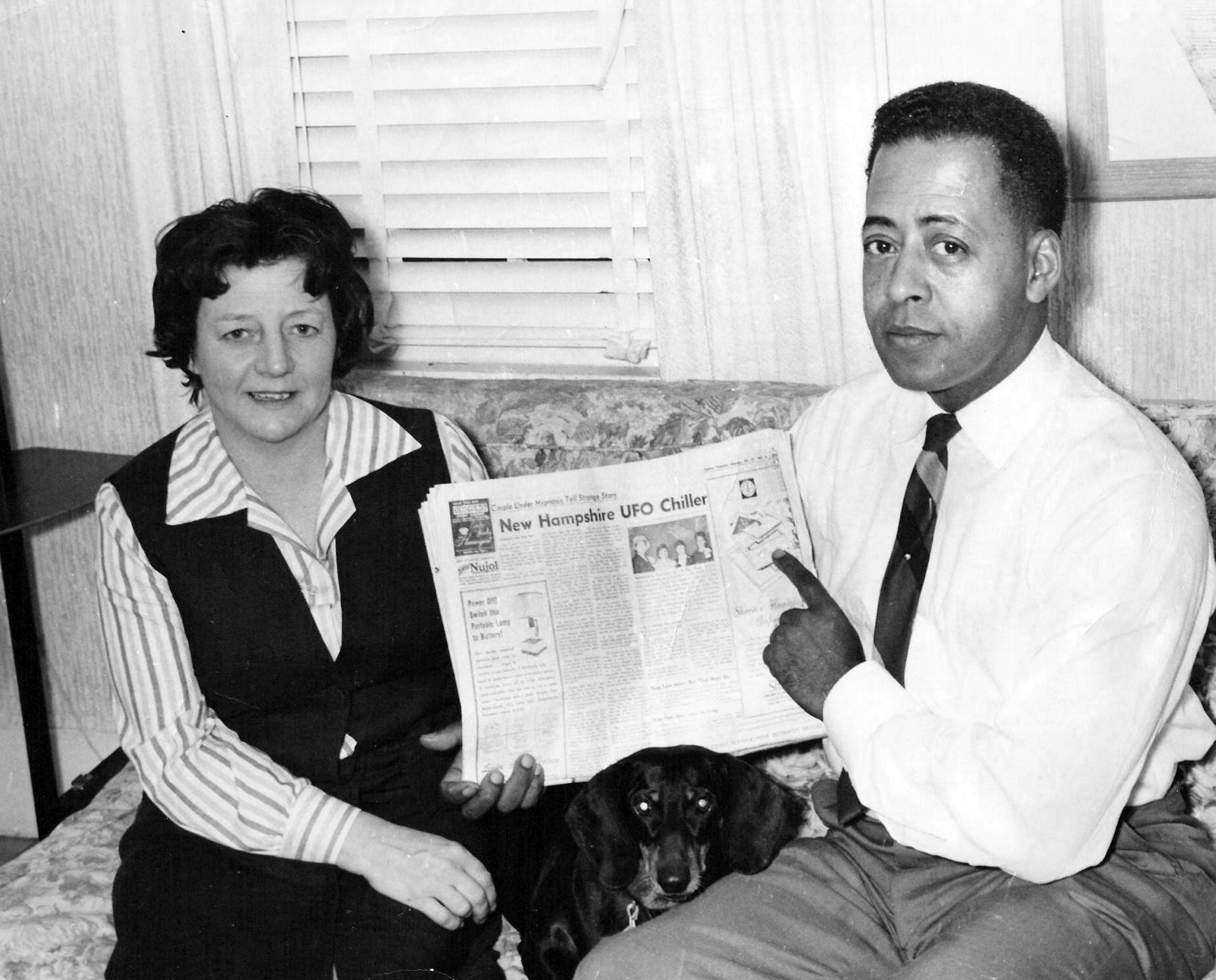 Betty and Barney Hill posing with a newspaper