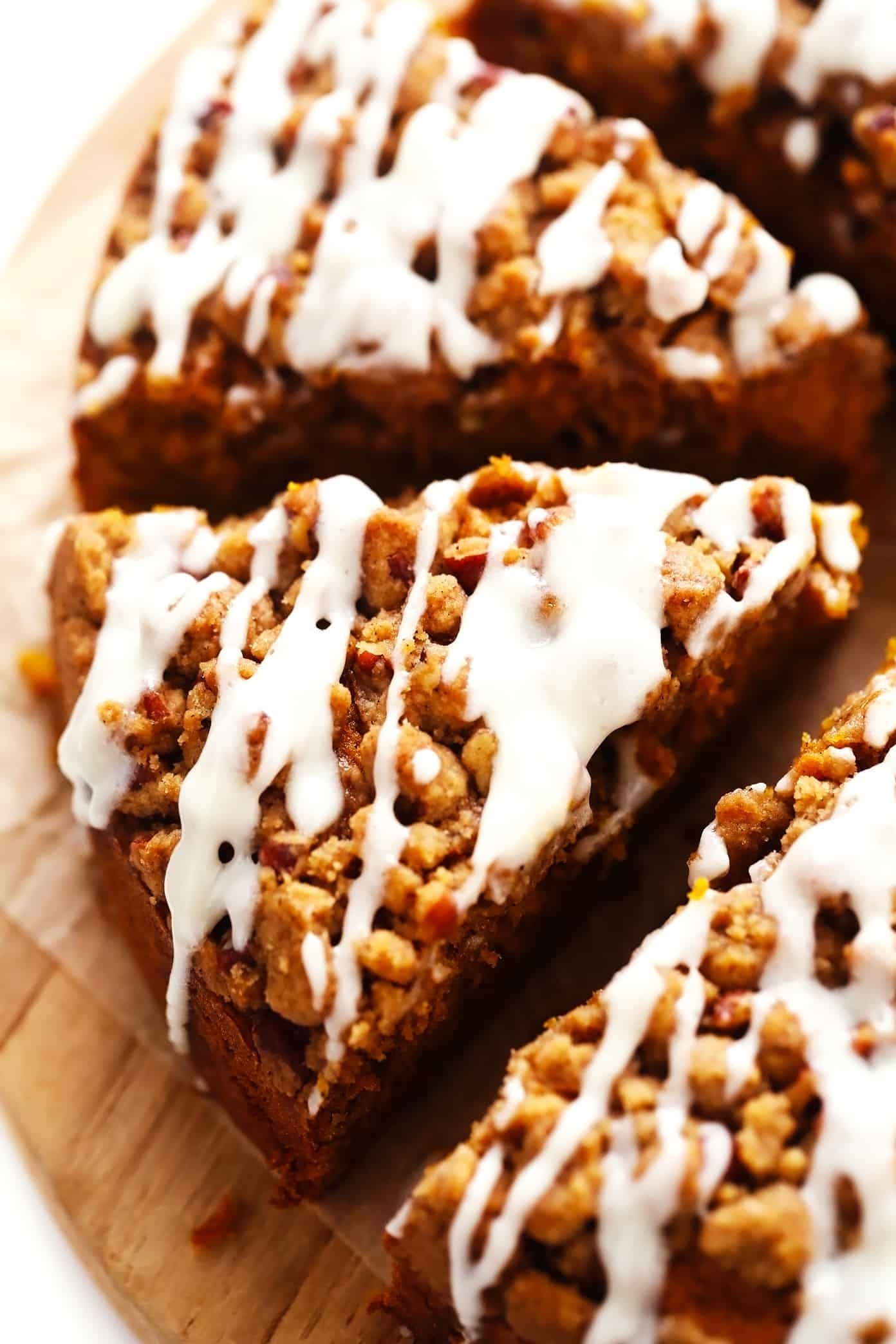 a pumpkin coffee cake sliced and topped with streusel and icing
