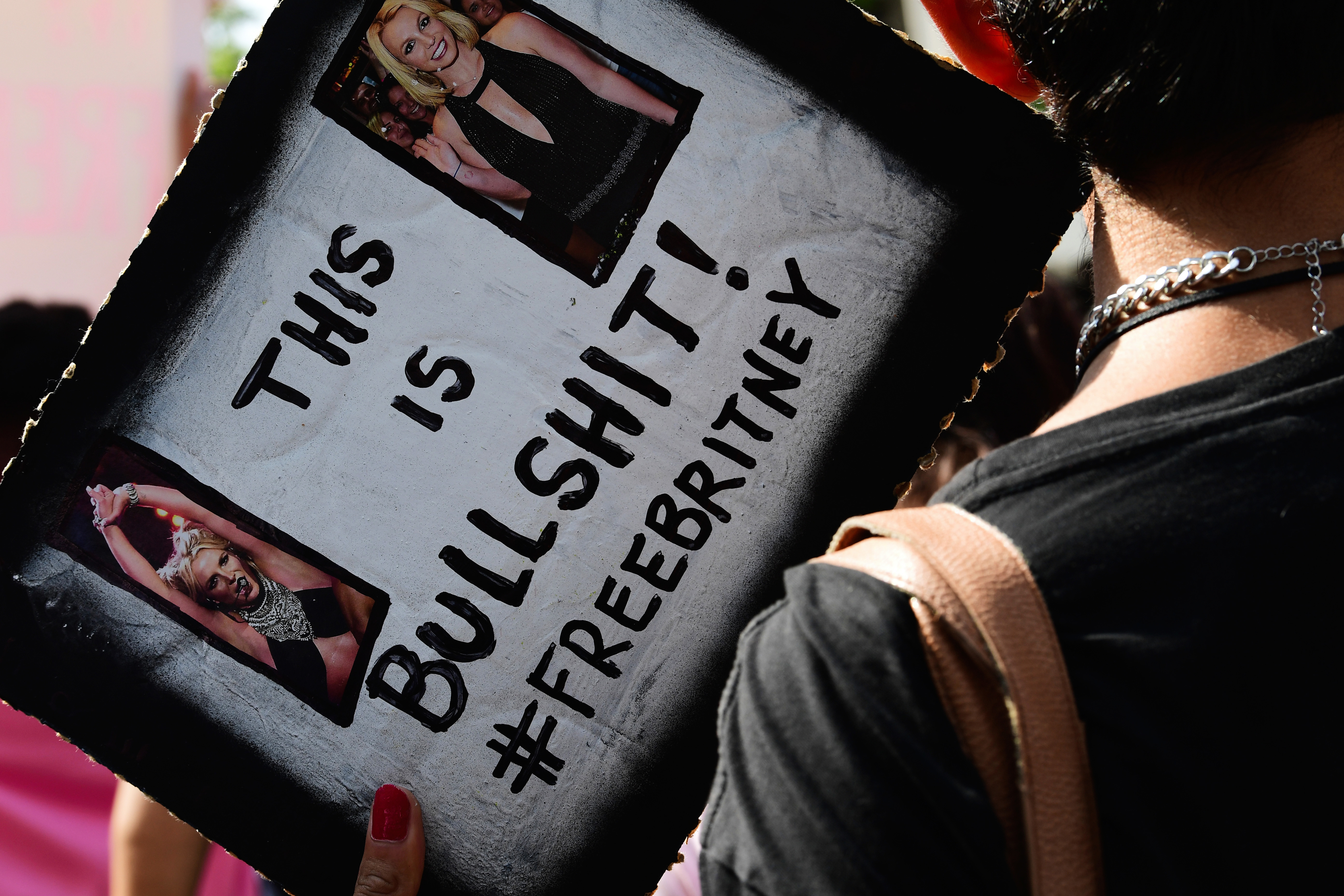 A person holding a flyer that says, &quot;&quot;This is Bullshit! #freebritney&quot;