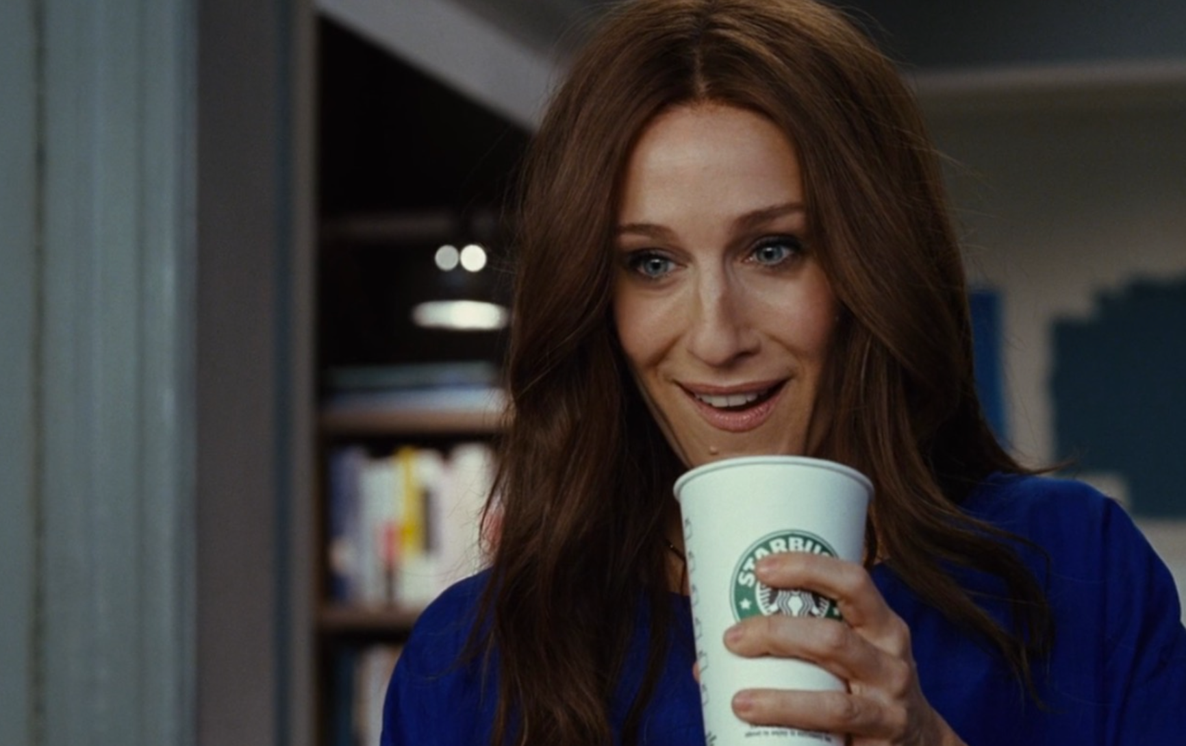 Carrie Bradshaw holding a coffee.