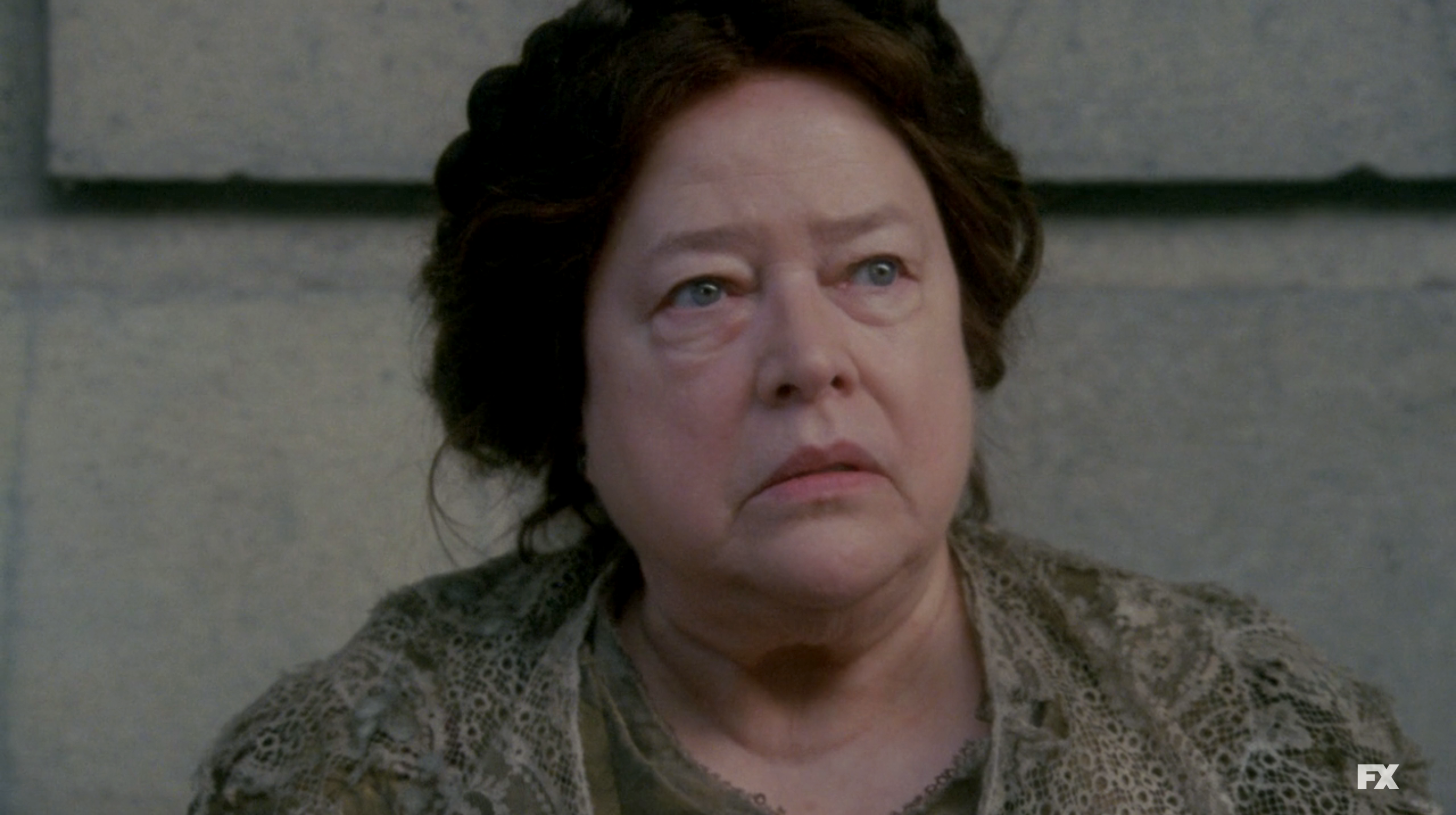 Kathy Bates as Madame Delphine staring into the distance