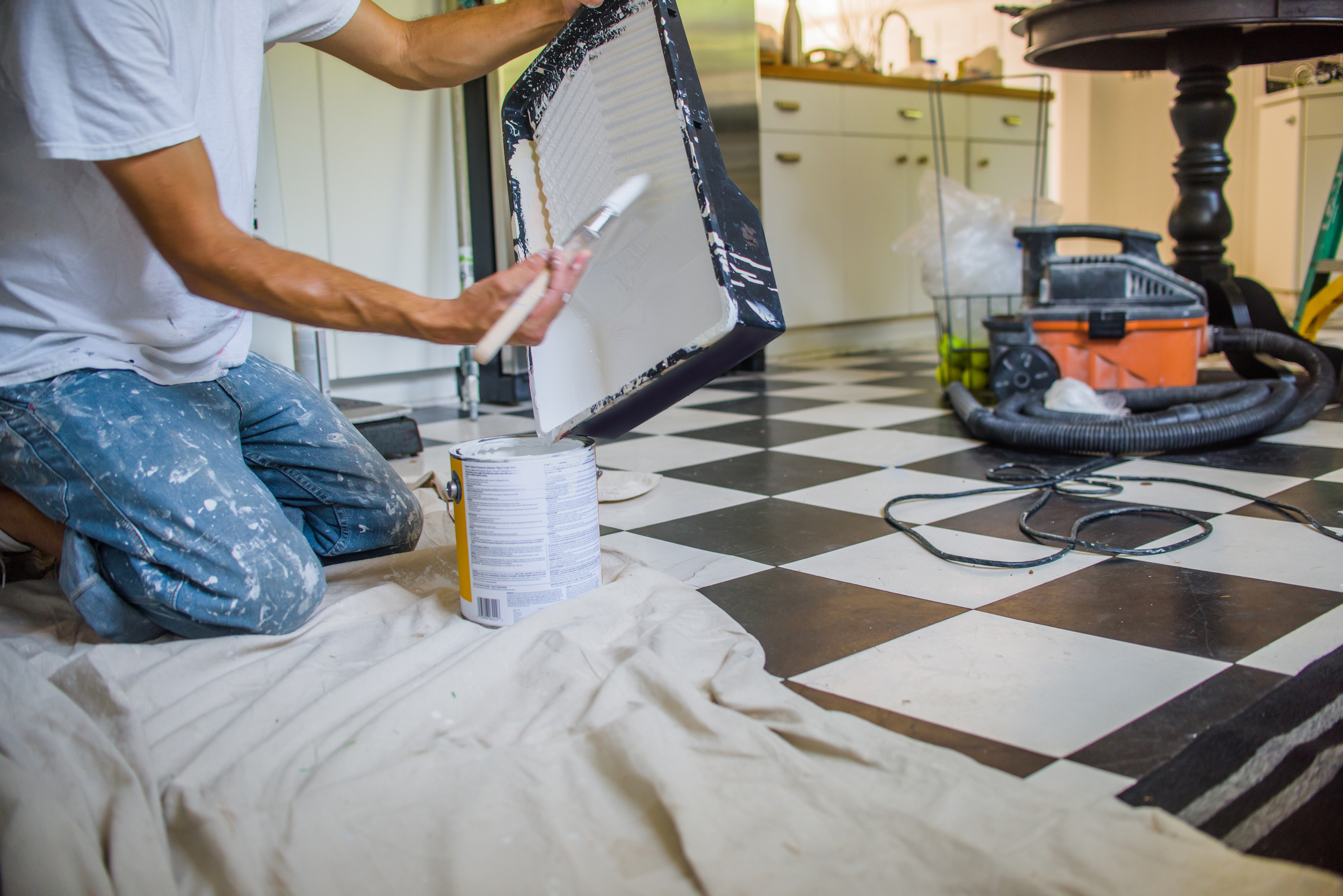 A man is putting paint into a tray