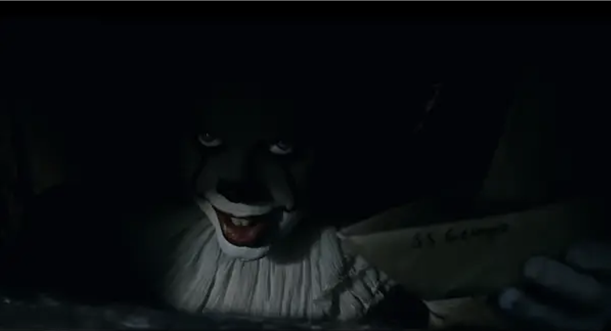 A really scary clown smiling in the dark