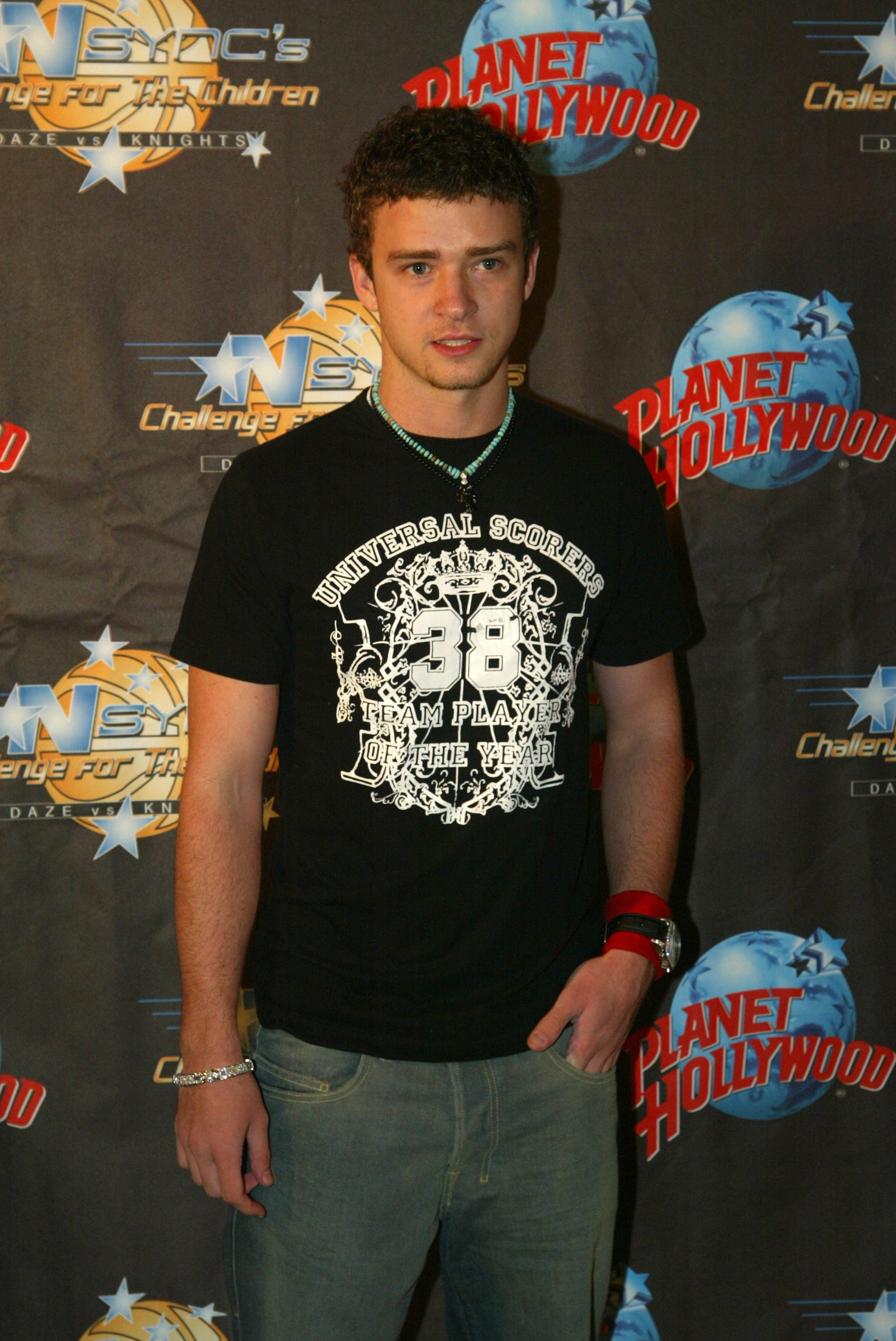 Close-up of Justin at a media event with curly hair and wearing jeans and a T-shirt