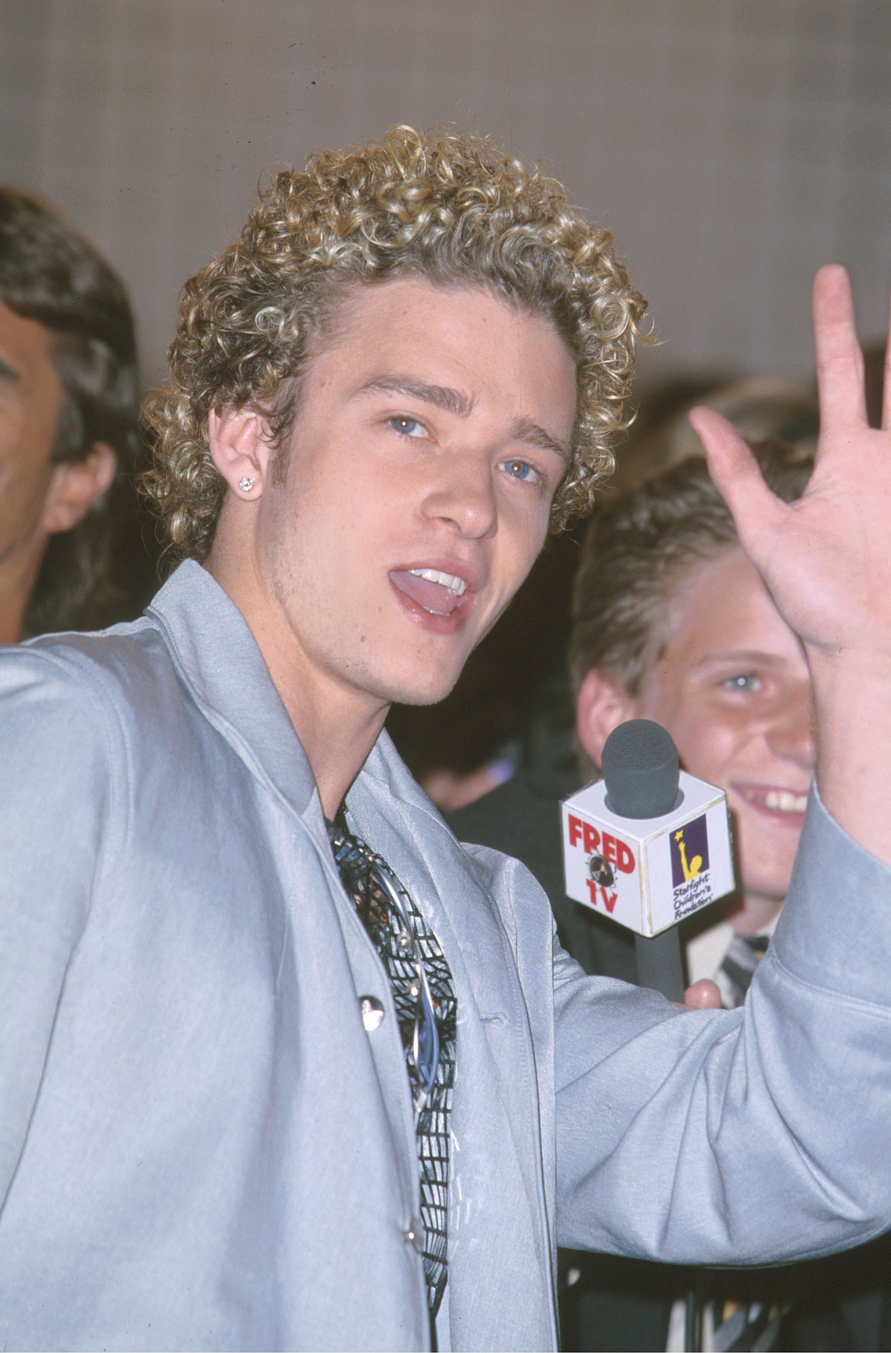 Close-up of Justin with curly hair waving