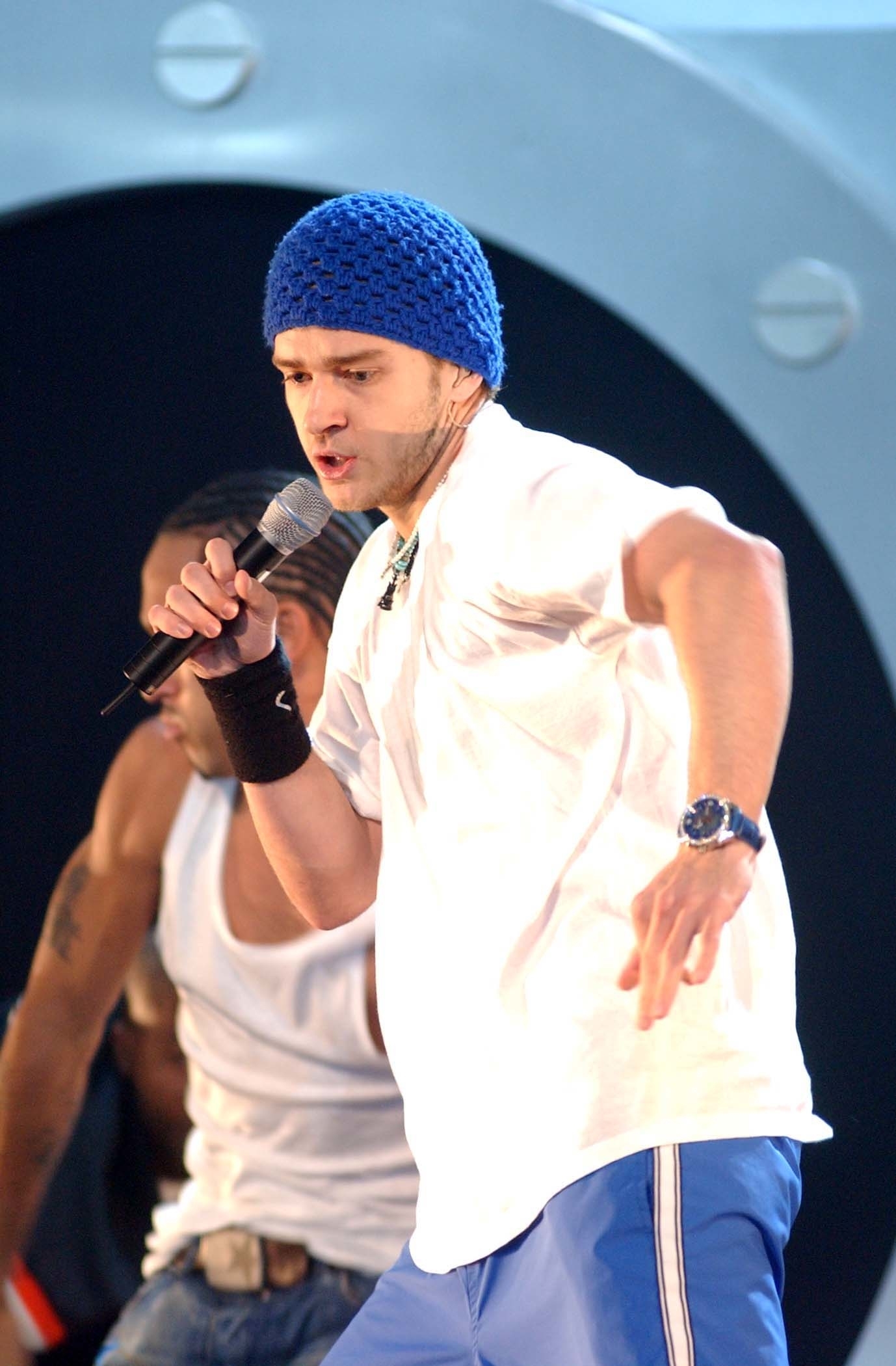 Justin wearing a knit beanie and performing onstage