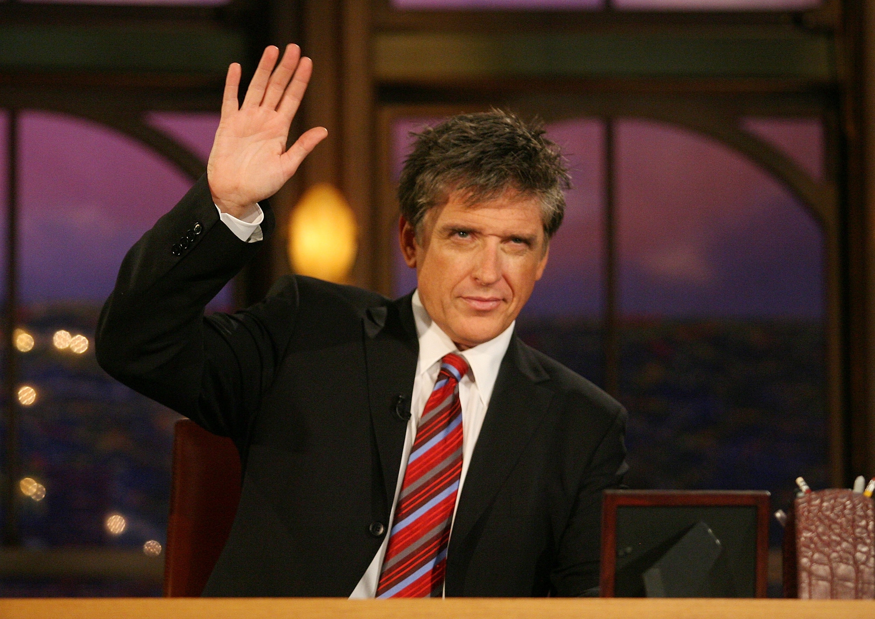 Close-up of Craig waving and wearing a suit and tie