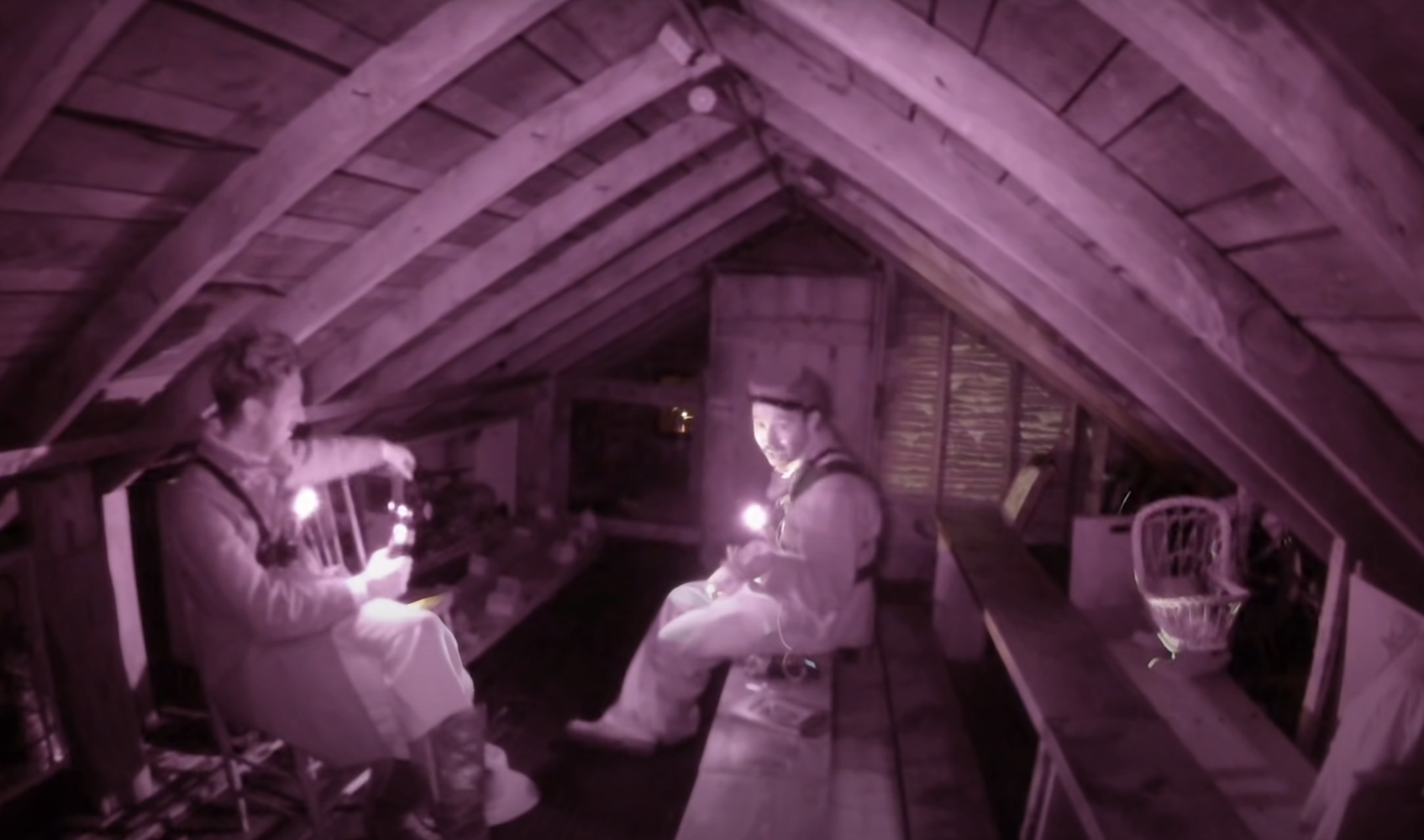 stories about haunted dolls two people in an attick with flashlights