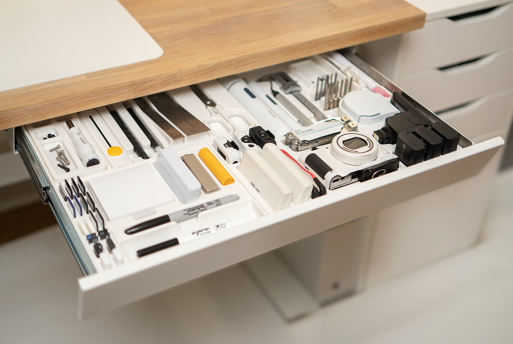 Custom 3D-printed object holders in drawer for pens, cameras, and other tools