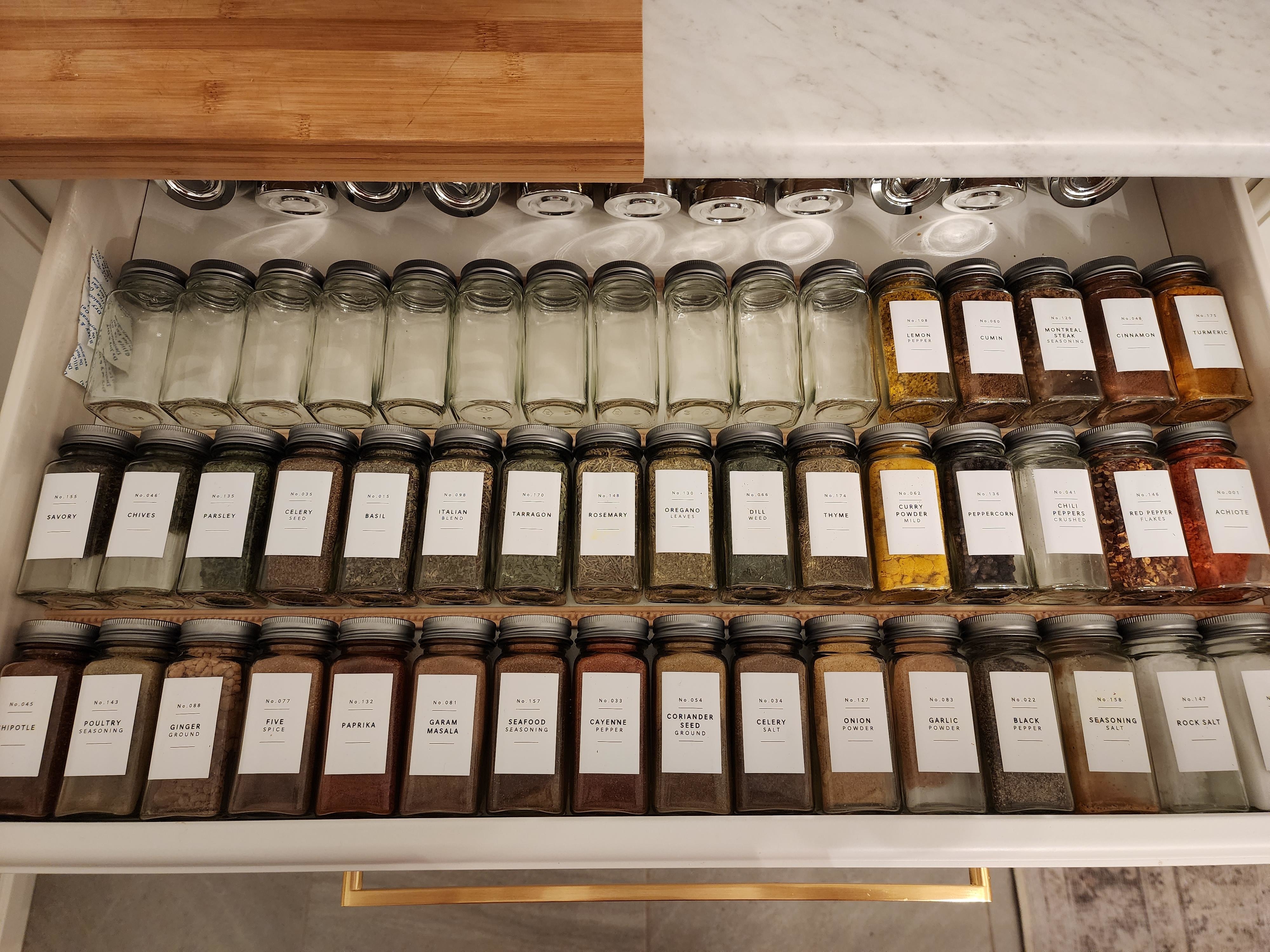 Spice jars lying flat in a large, slide-out drawer