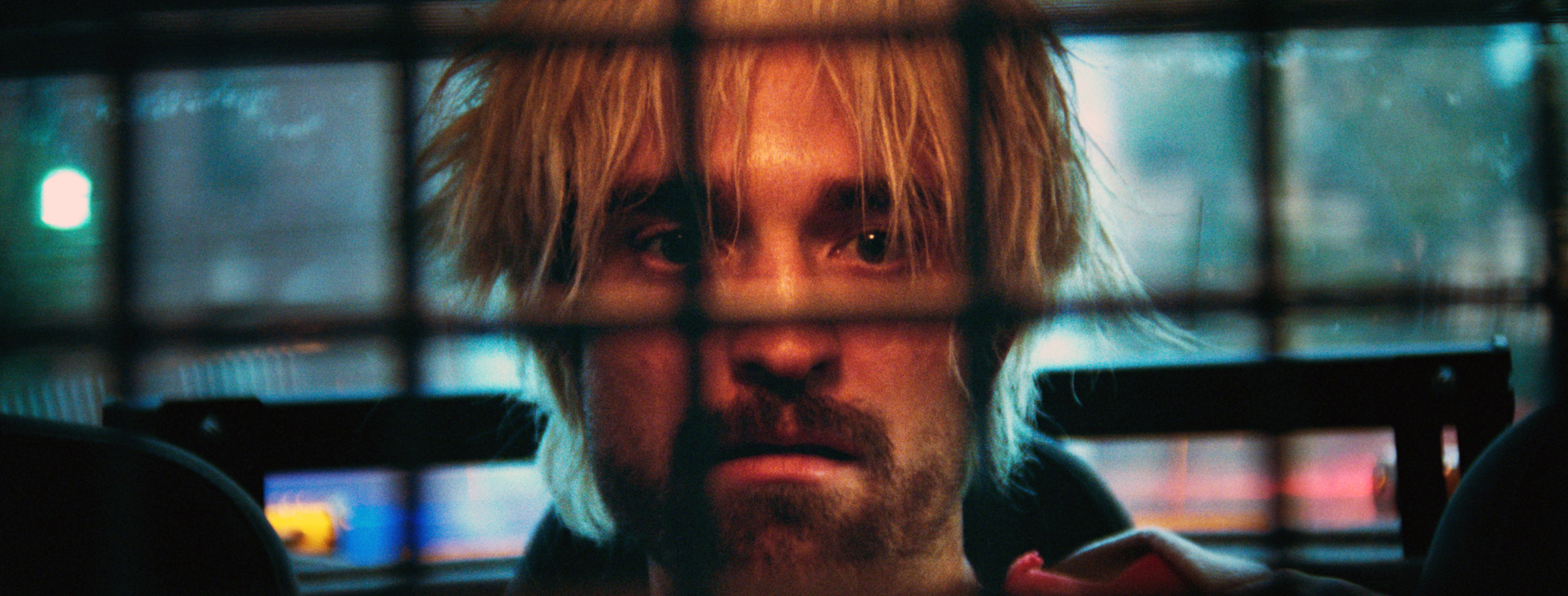 closeup of him in the back of a cop car in the film