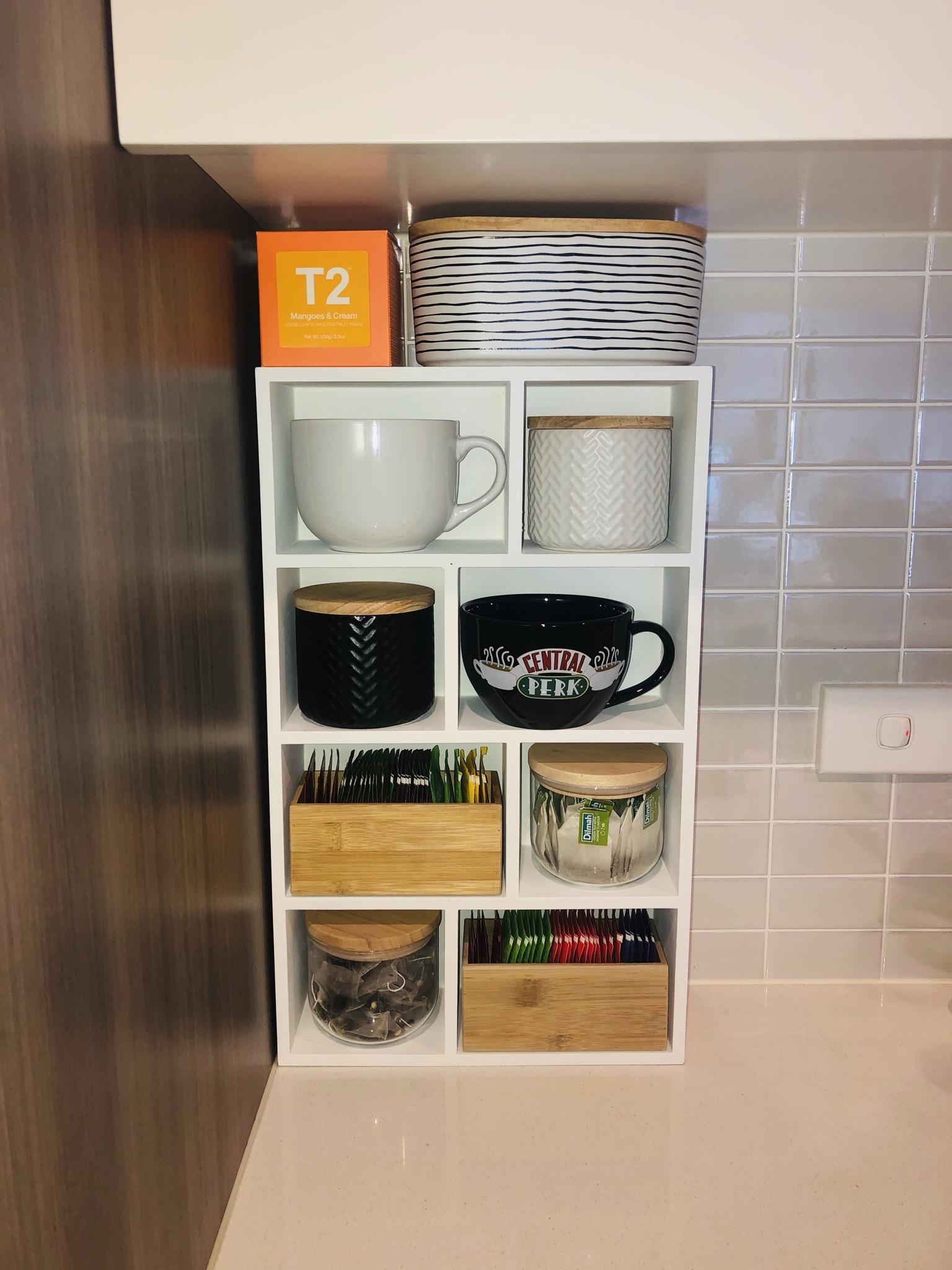A tea holder that&#x27;s vertical and holds mugs, tea, and tea accessories