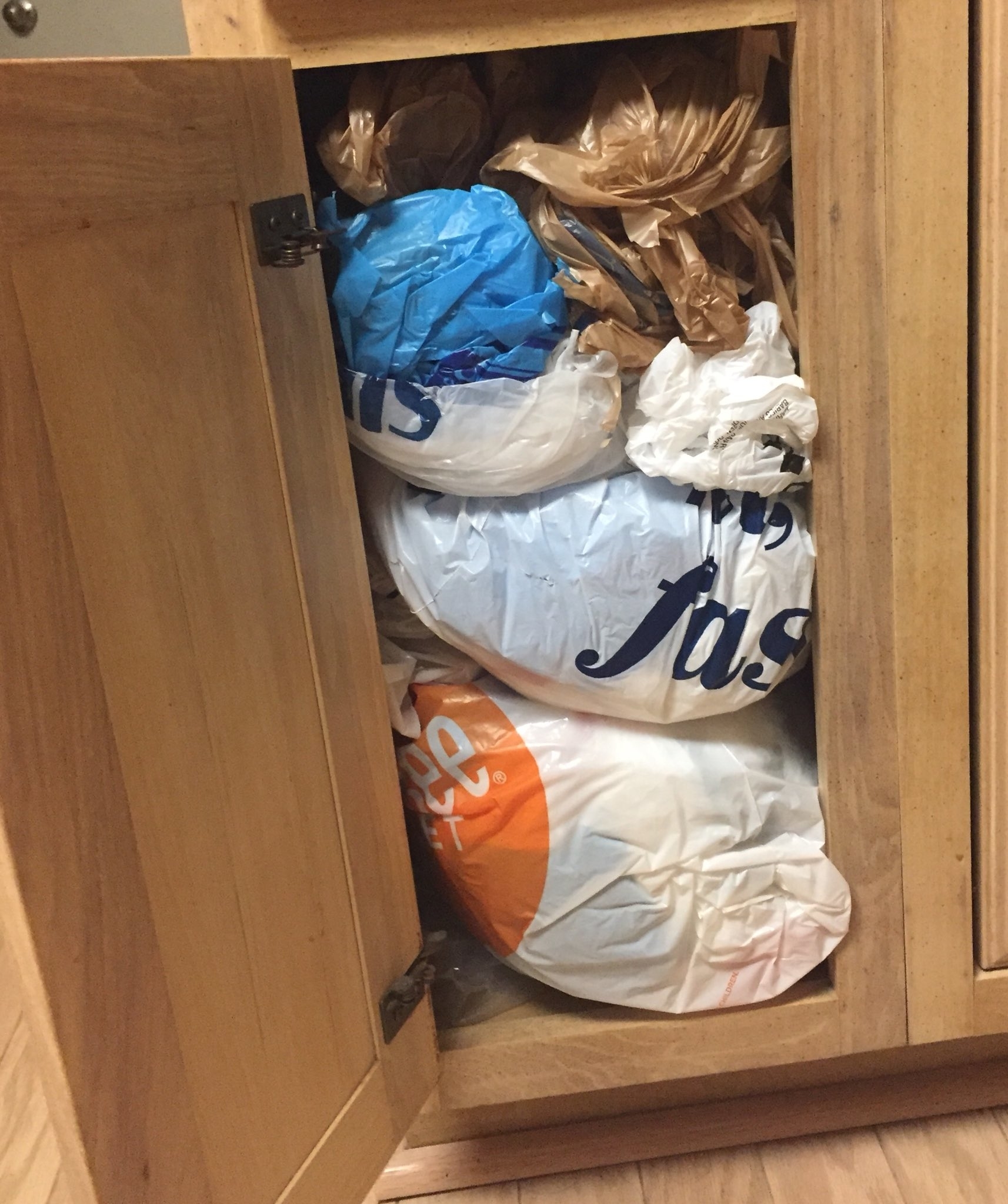 A cabinet stuffed with plastic bags inside each other