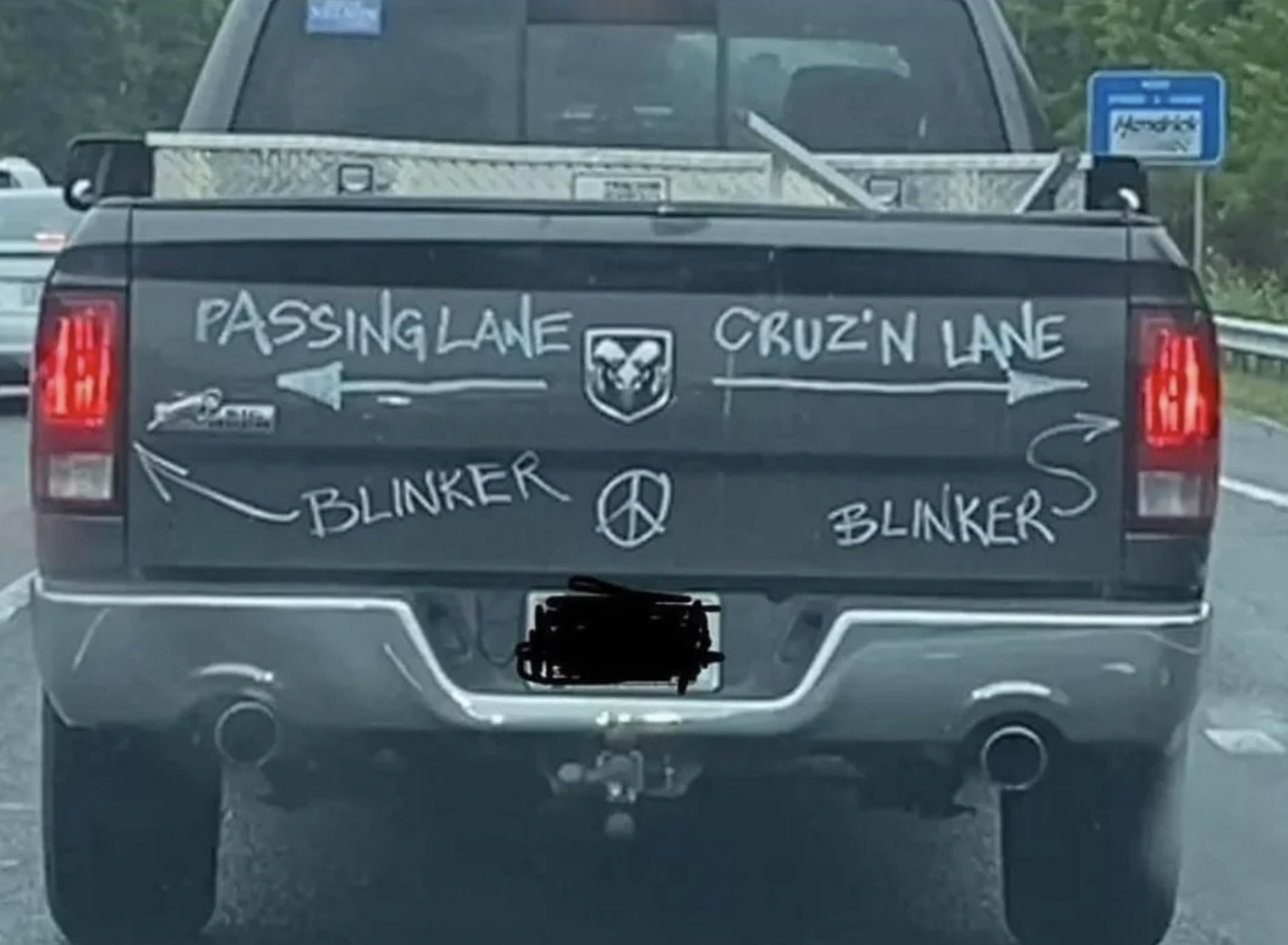 back of a truck has insructions for driving, an arrow points left for the passing lane and an arrow pointing right for the cruising lane, also with arrows to the blinkers