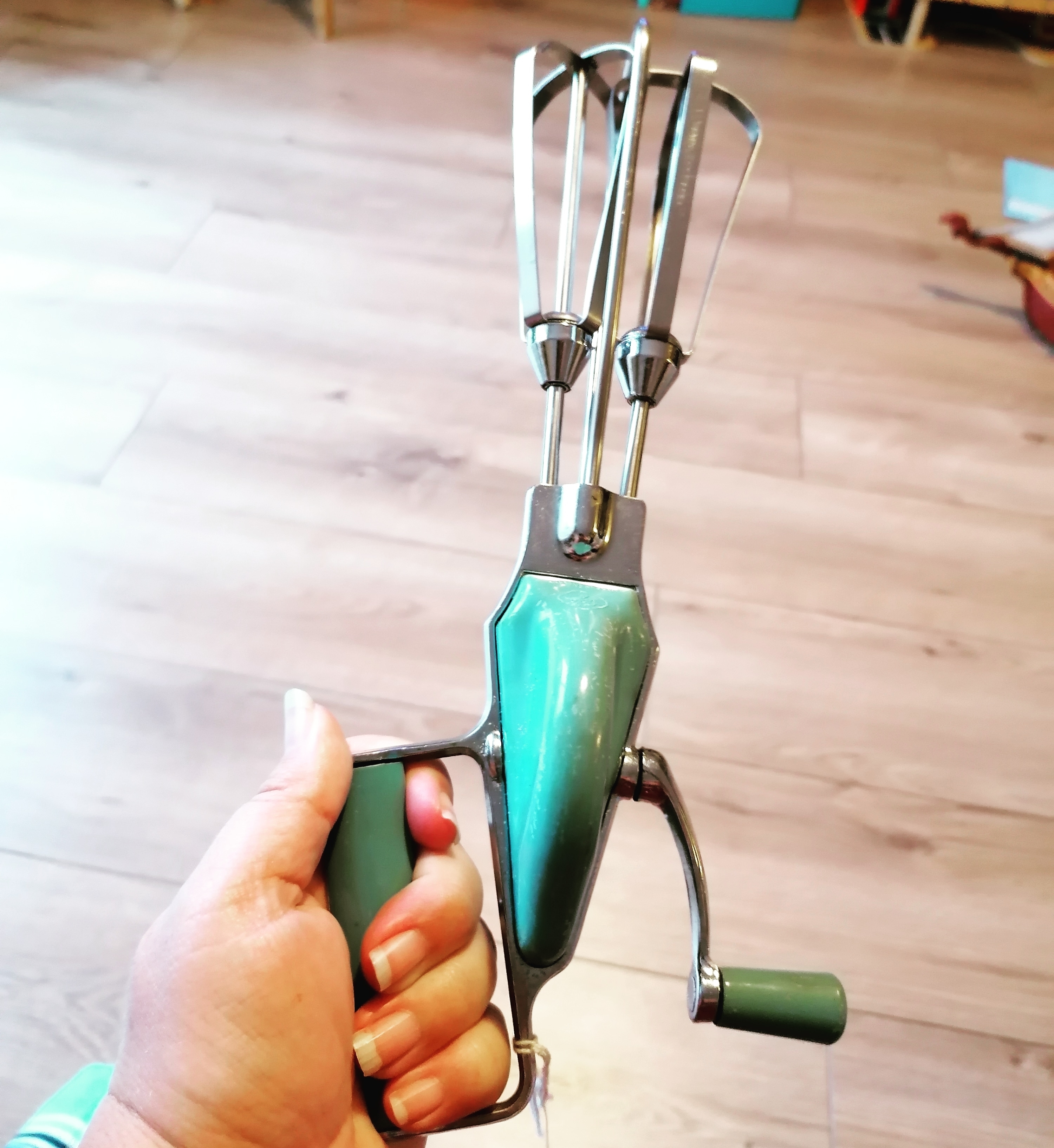 person holding a hand mixer with a lever for spinning it