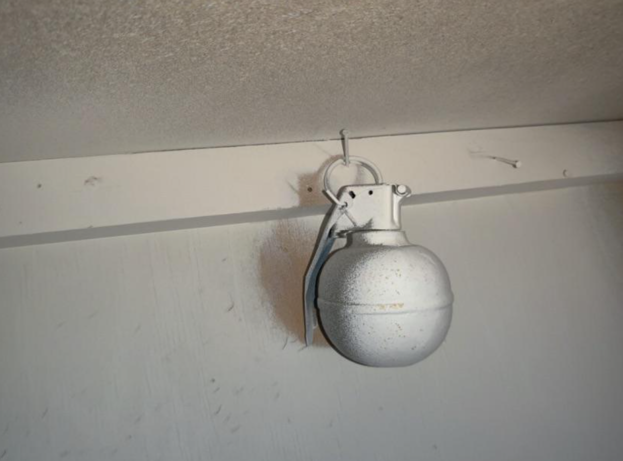 a grenade that&#x27;s been painted over hanging on the wall