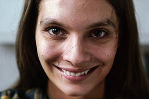 Caitlin Stasey smiling creepily as Laura in Smile