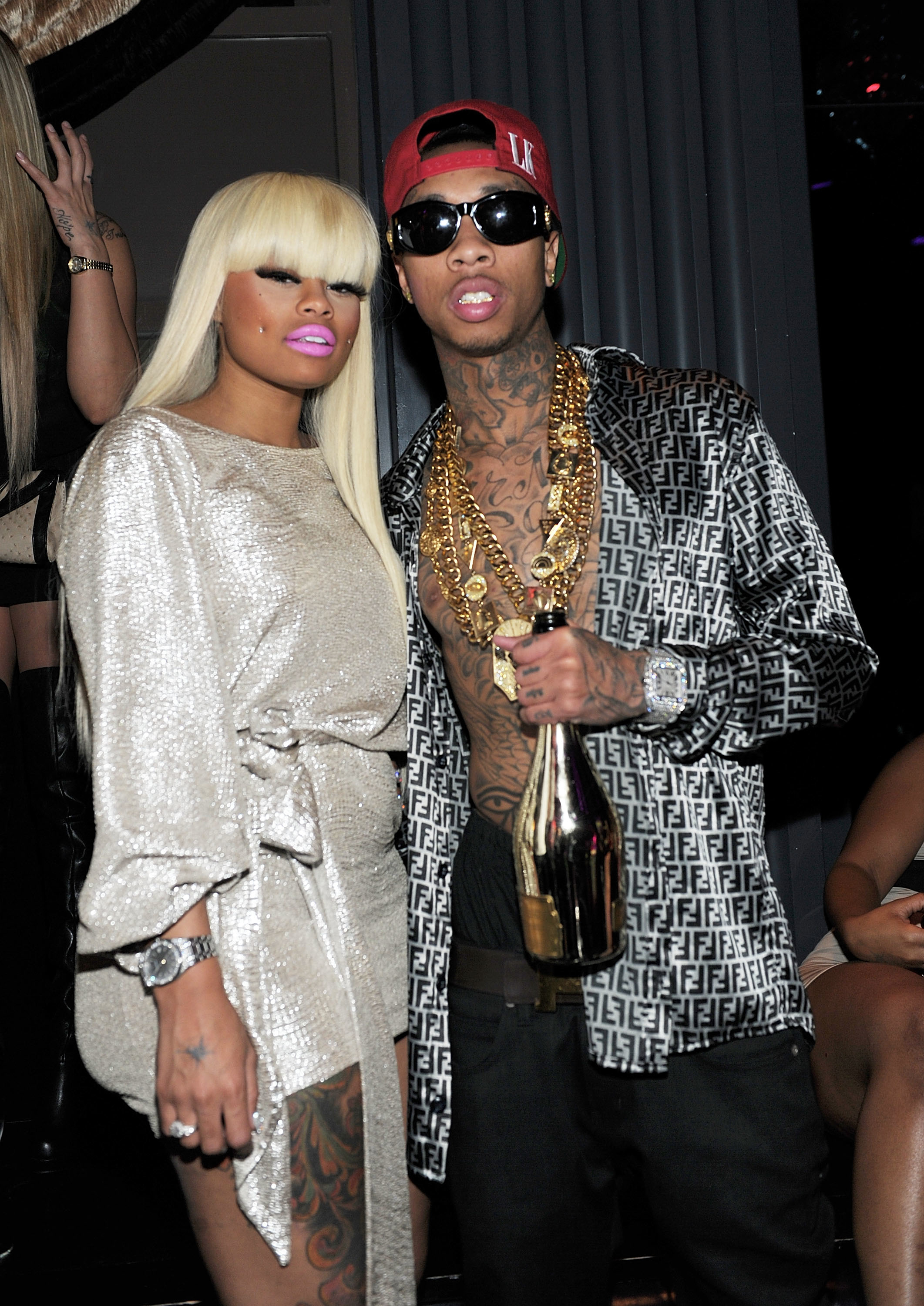 Close-up of Tyga, holding a champagne bottle, and Angela