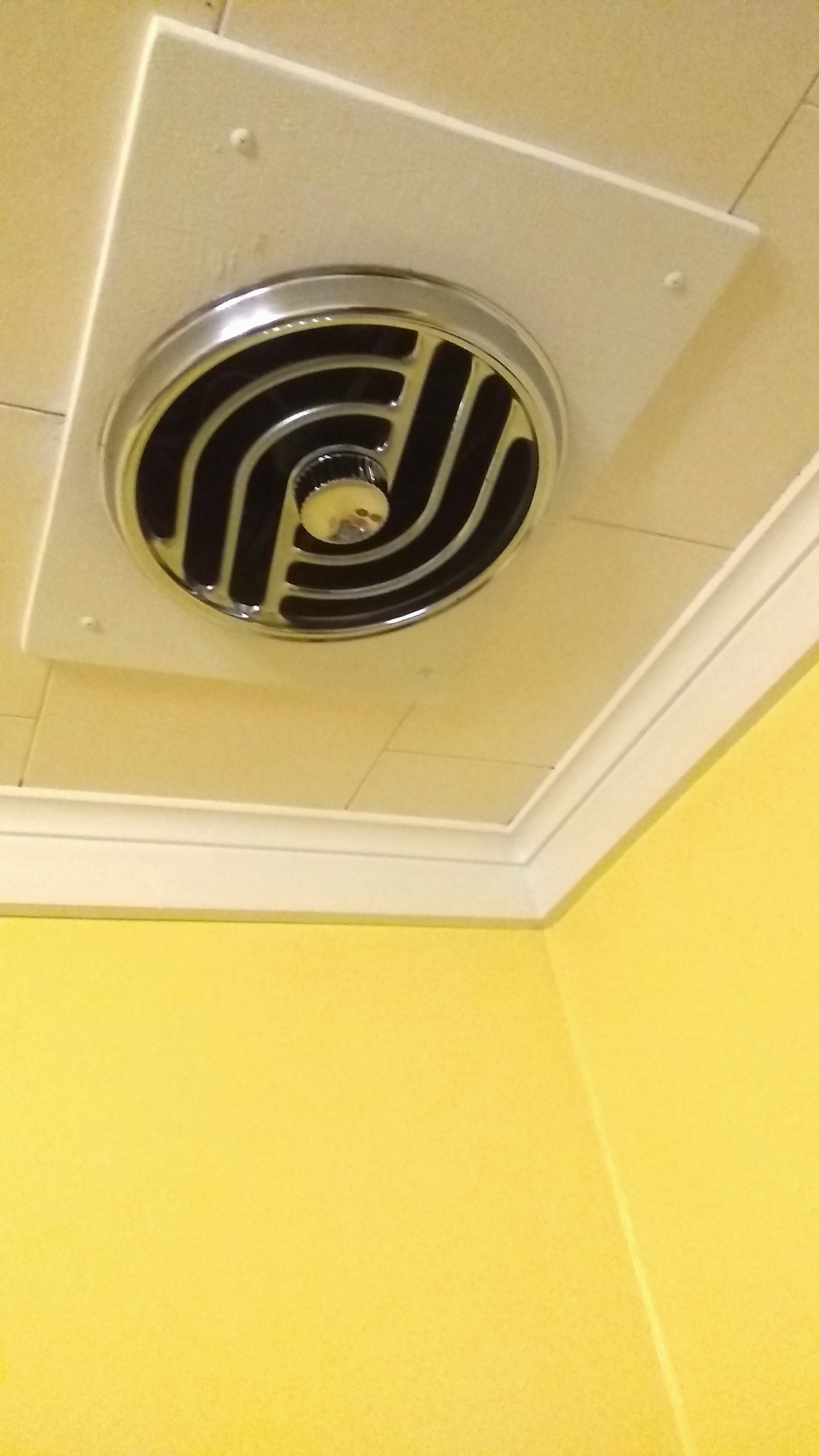 small, circular exhaust hood built into the ceiling
