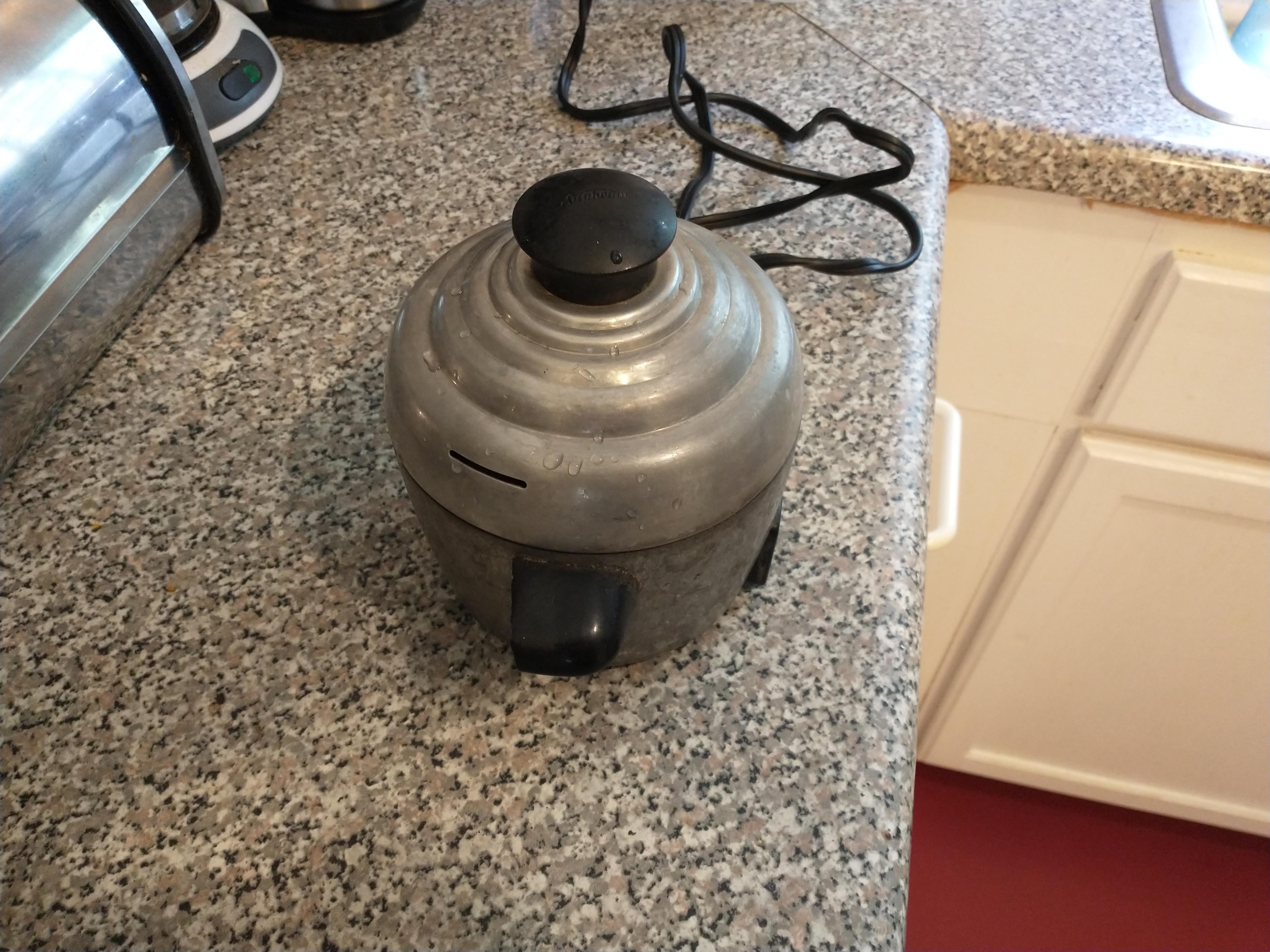 a thick-walled metal egg poacher on the counter