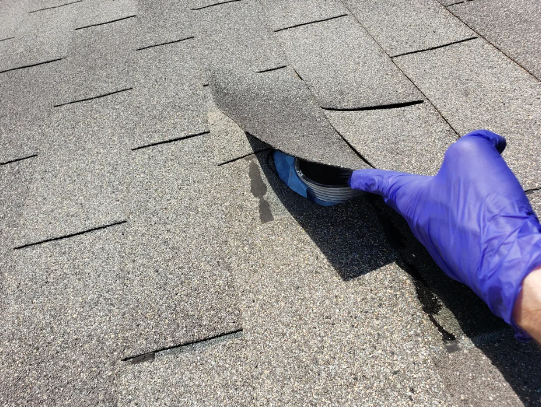 hand lifting up the shingle that&#x27;s covering the ventilation