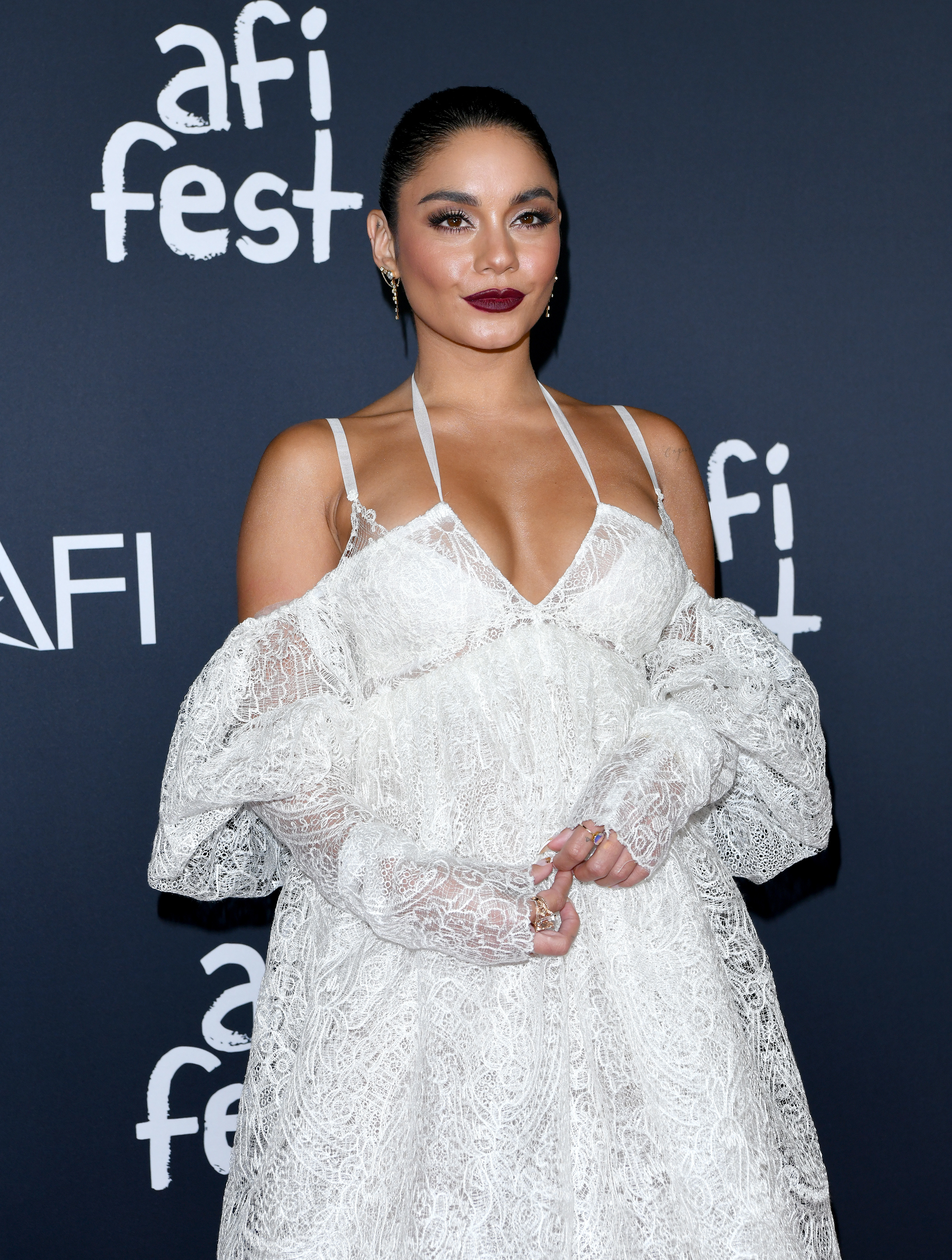 Close-up of Vanessa in a long, off-the-shoulder lacy dress at a media event