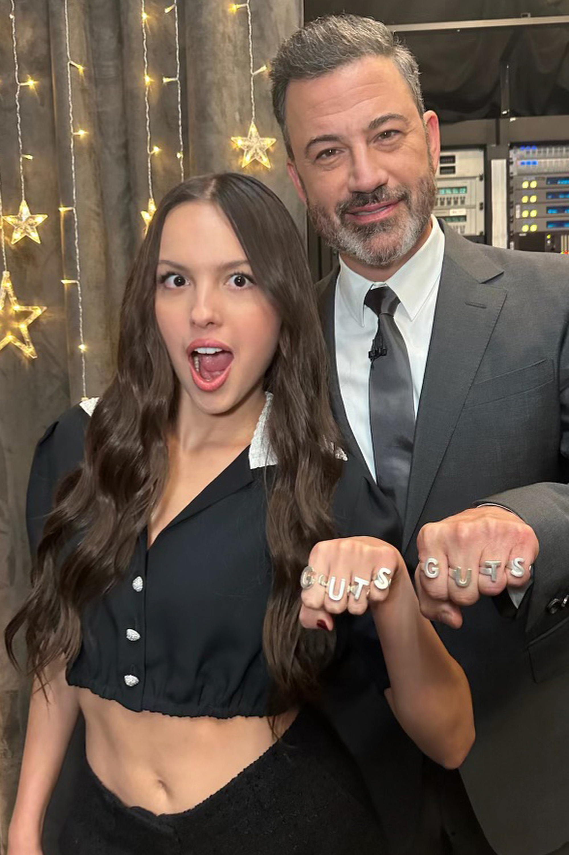 Close-up of Olivia and Jimmy holding up &quot;Guts&quot; rings