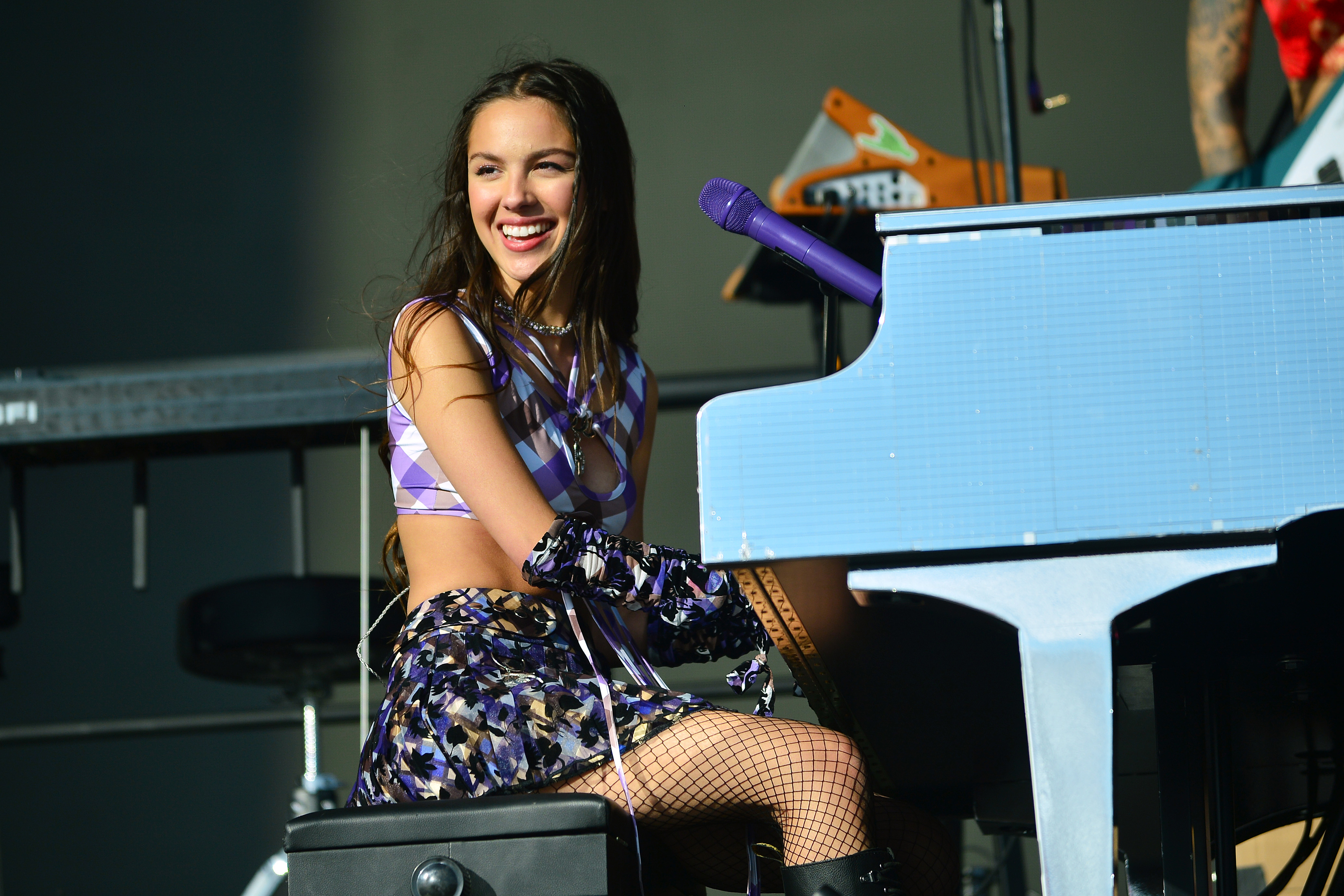 Close-up of Olivia onstage sitting at a piano