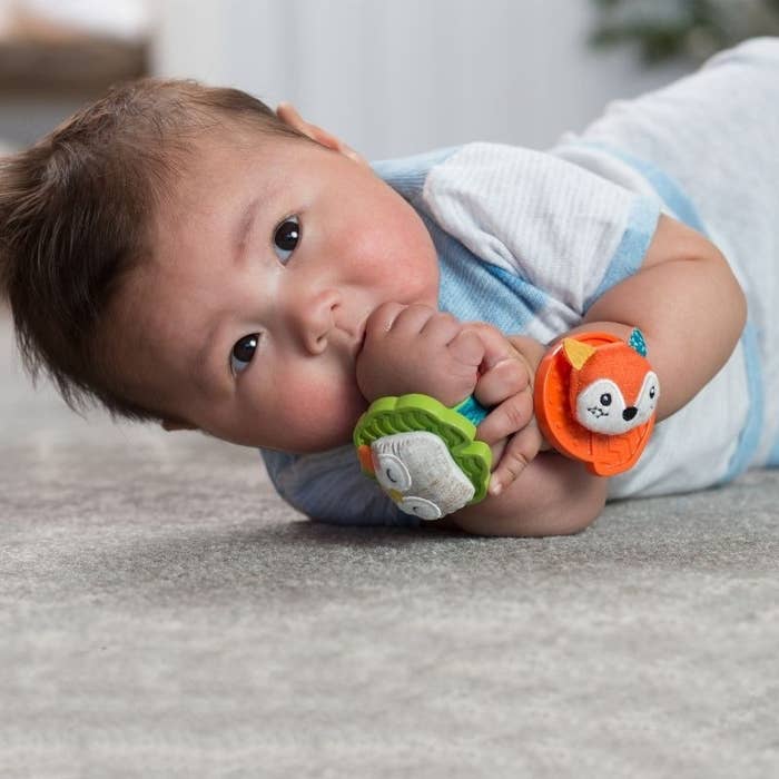 Baby with rattles on its wrists